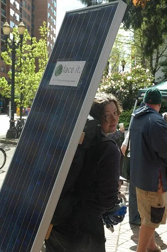 Carrying a solar panel while working at Green Empowerment
