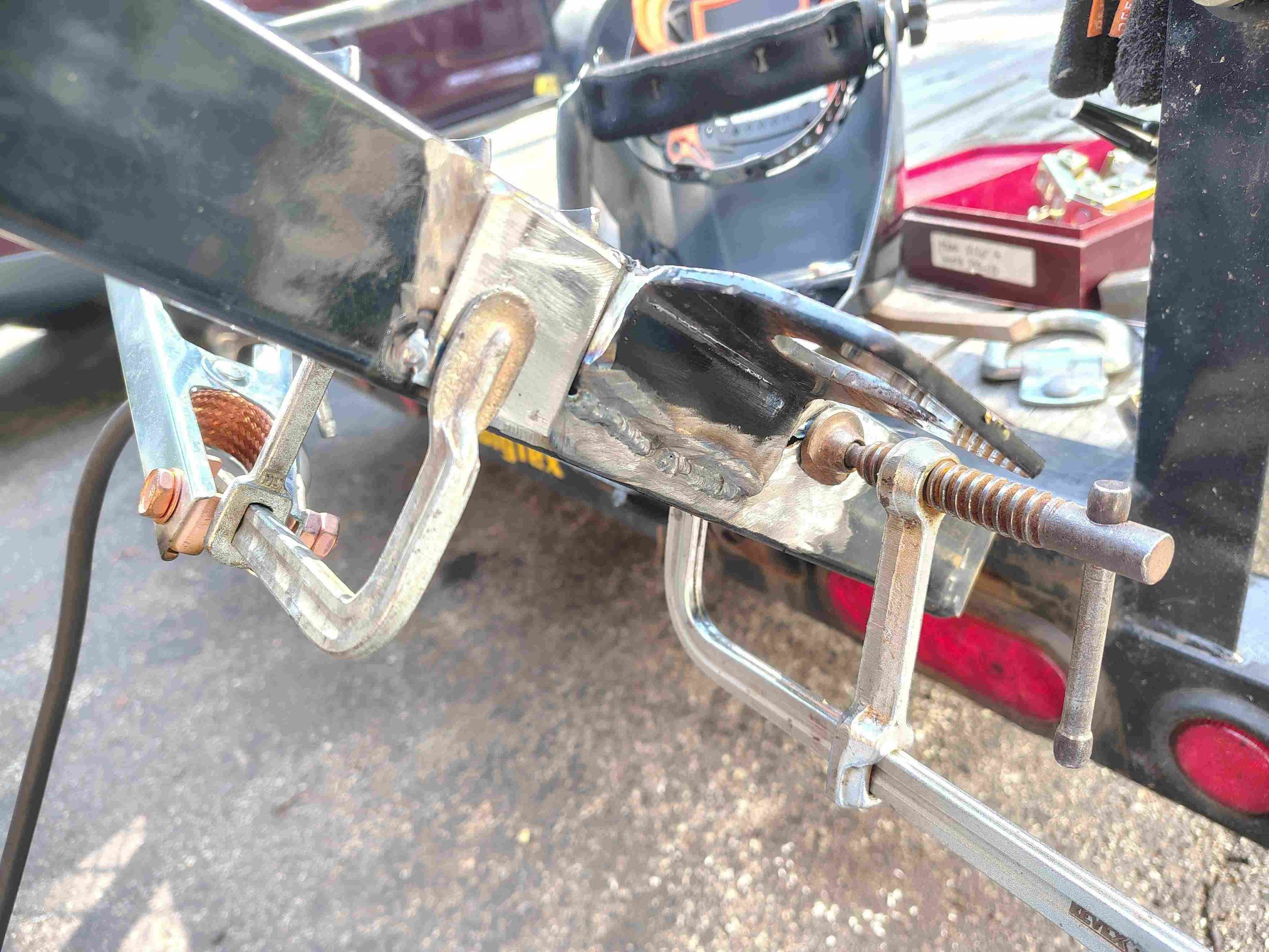 Repaired steel trailer box tube with weld complete and the first reinforcement patch clamped and tacked in place — steel trailer frame repair, PIE LLC Weld & Machine, Cecil County MD serving Maryland and Delaware