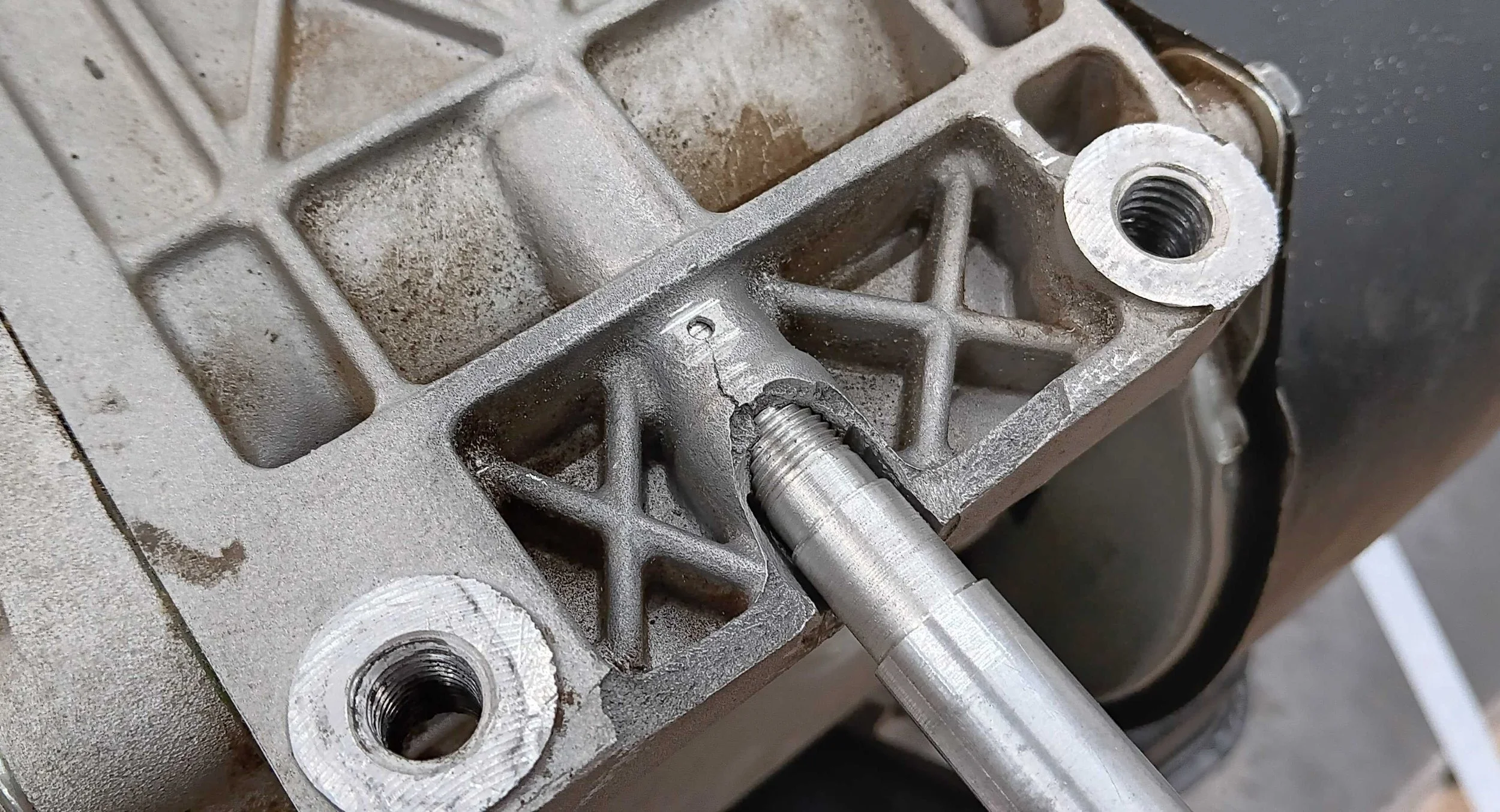 Cast aluminum oil drain port with custom plug installed and crack spot-drilled to stop it spreading — Cub Cadet cast aluminum repair, PIE LLC Weld & Machine, Cecil County MD serving Maryland and Delaware