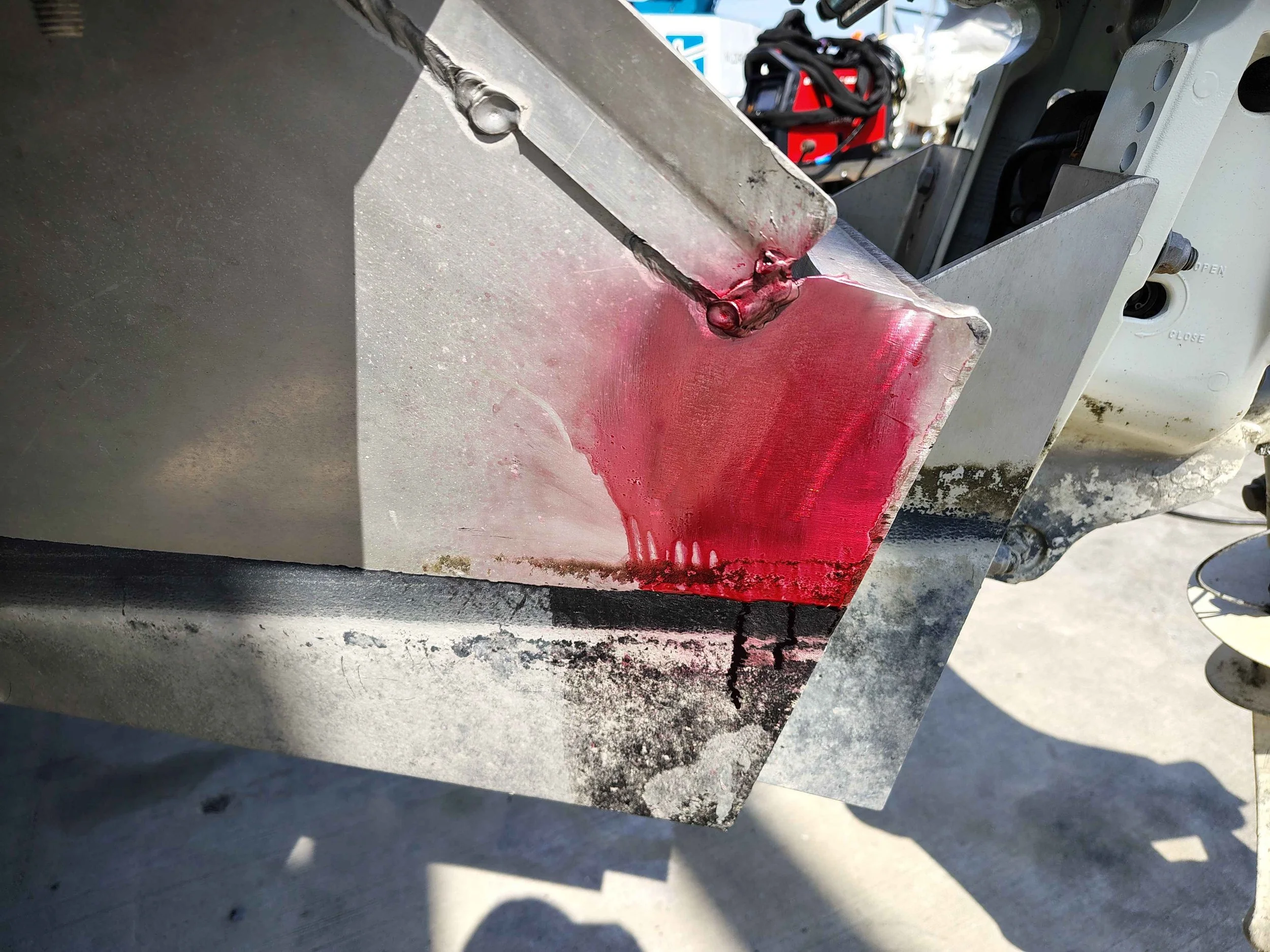 Dye penetrant developer revealing full crack length on aluminum boat transom before welding