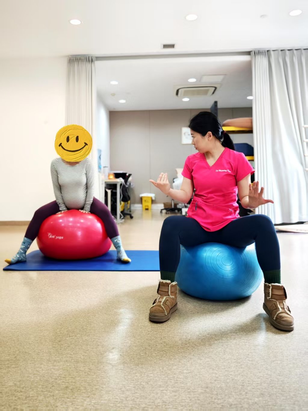 A woman and a child exercising with stability balls in a wellness or therapy room.