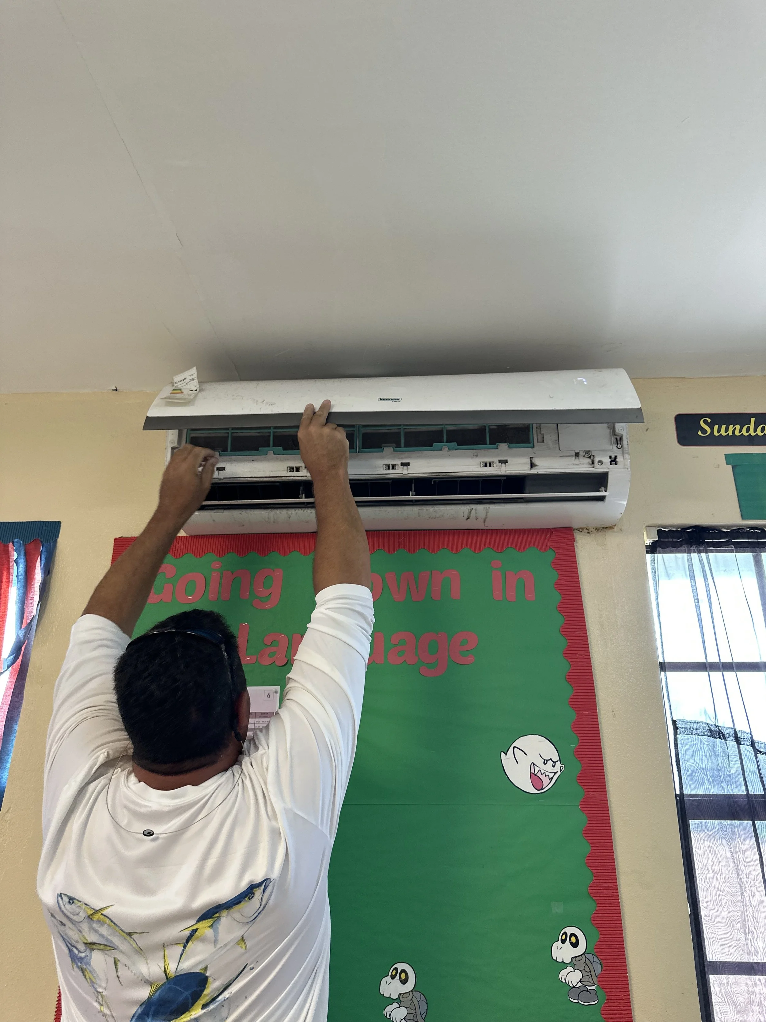 Volunteer Joe H cleaning air conditioners