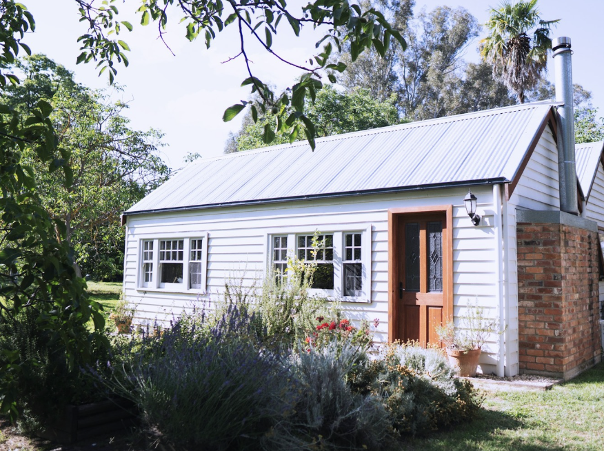 An image of a cottage set in a garden on a farm property