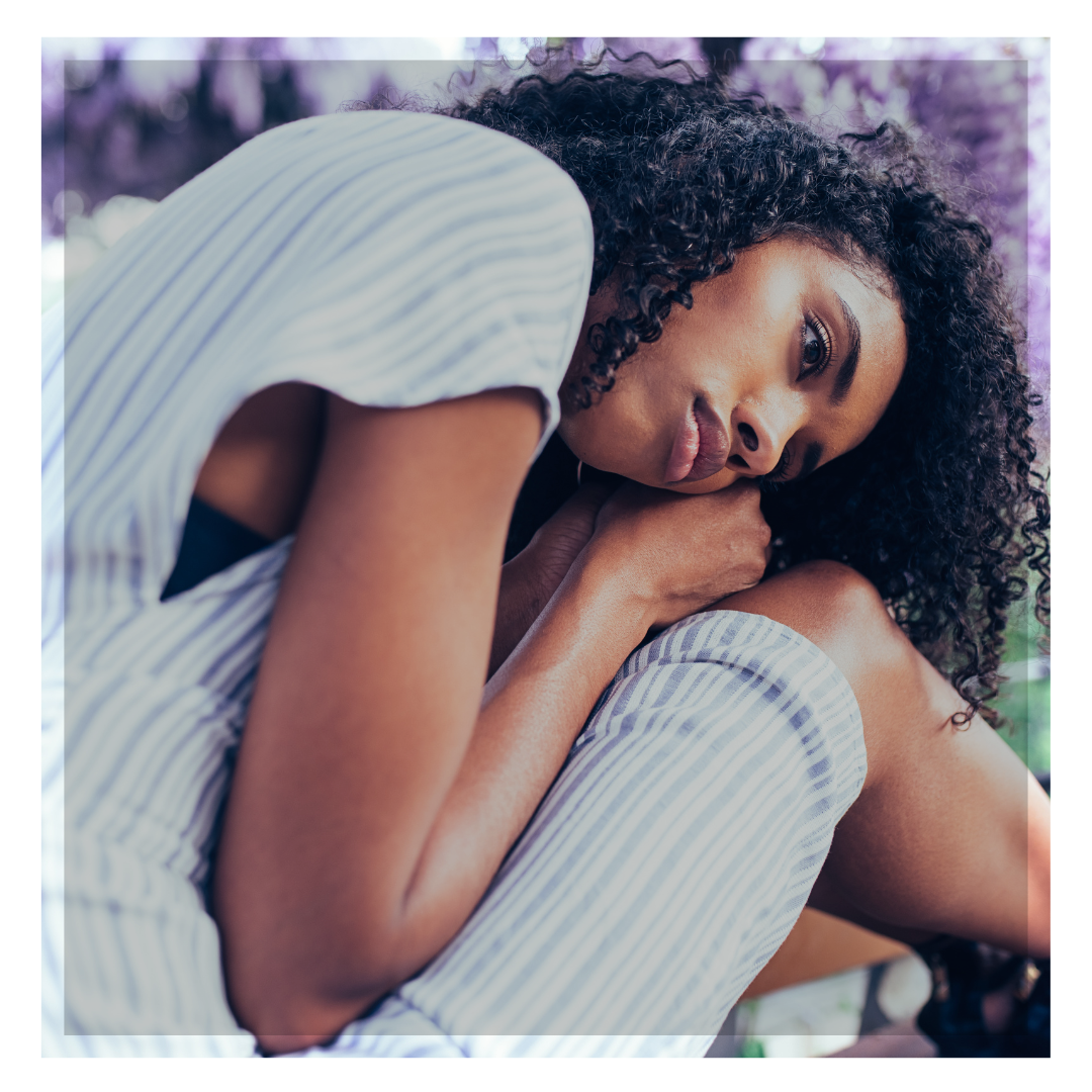 Woman holding her head in her lap, illustrating stress, shame, and disconnection around intimacy