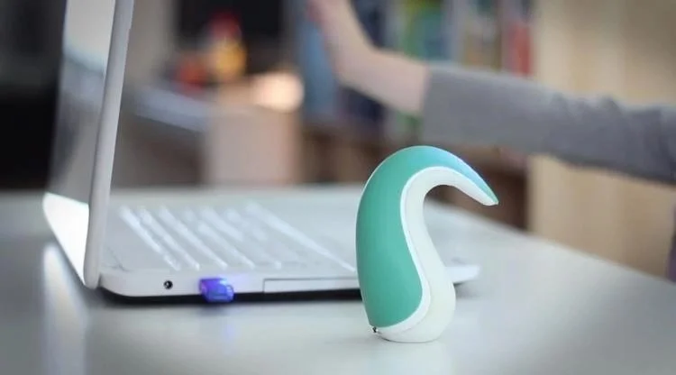 Discreet wearable vibrator placed beside a laptop, representing technology-assisted intimacy and modern sexual wellness.
