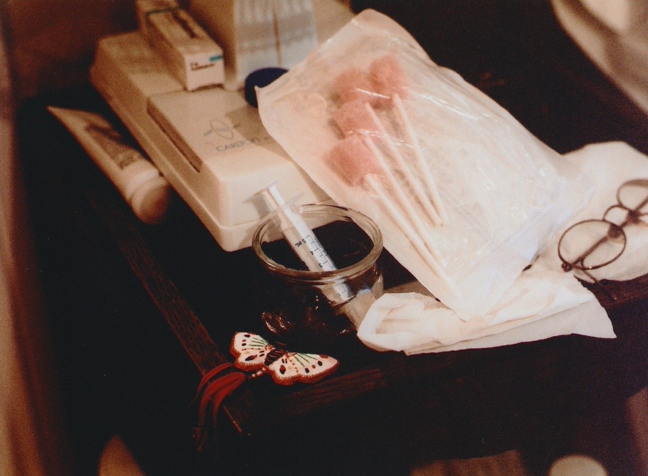 The bedside table; mum's glasses, the oramorph syringe, the foam sticks to wet her mouth, a Christmas decoration.