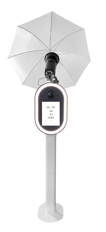 A teleprompter with a built-in light ring and an umbrella attached, mounted on a white stand.