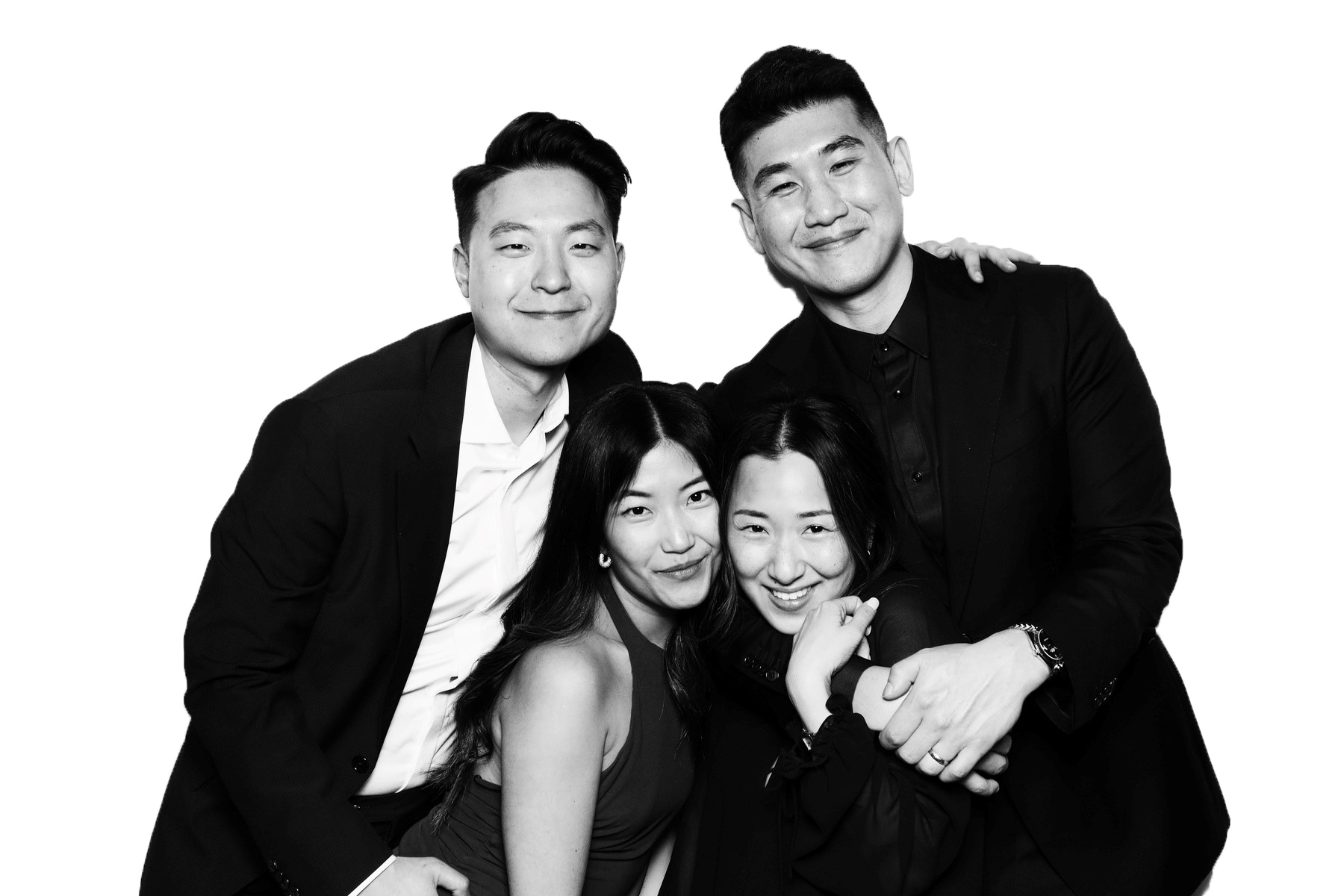 Four people, two men and two women, are posing together in black and white. They are smiling and appear happy.