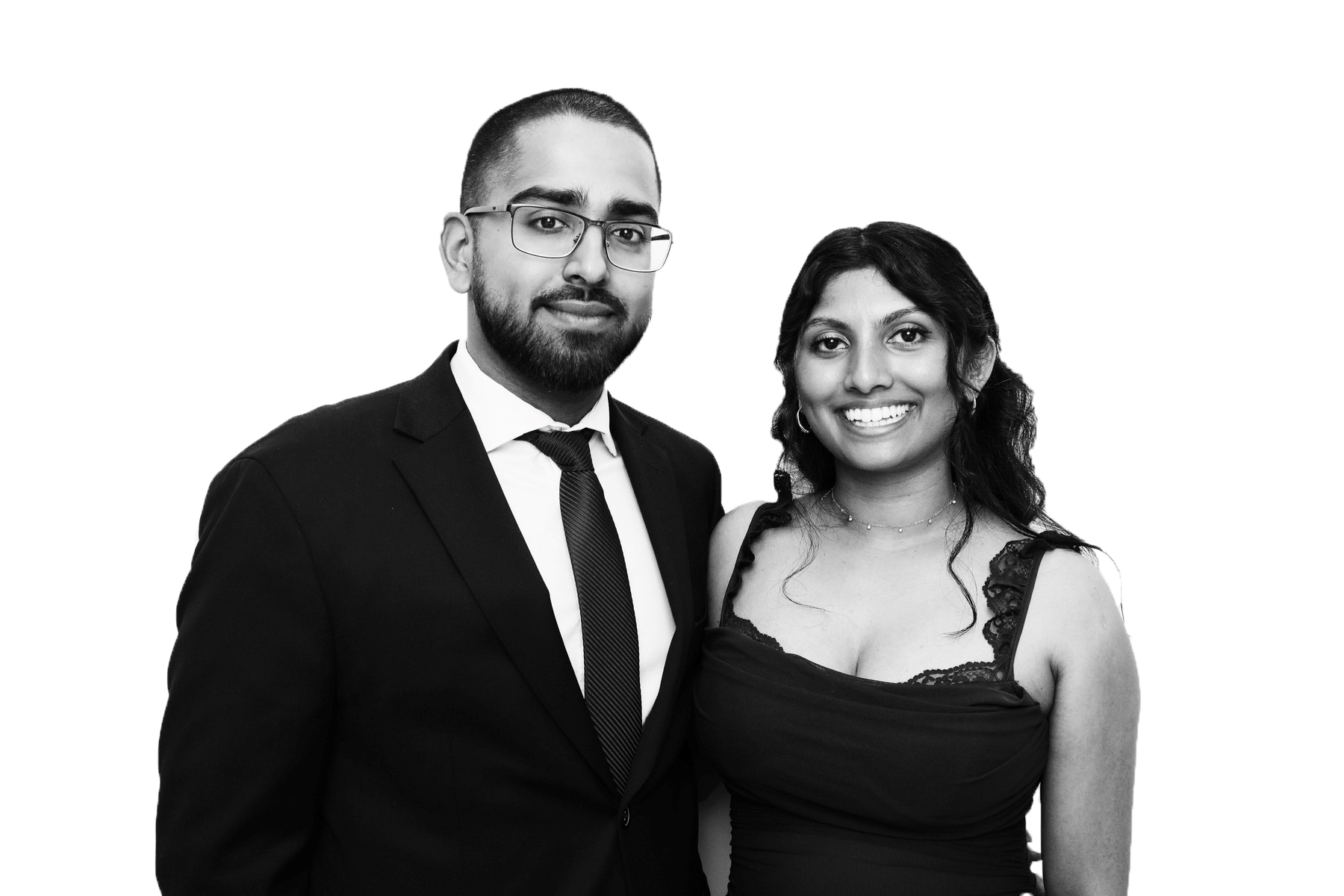 A Black and white photo of a man in a suit and a woman in a dress, standing close together and smiling.