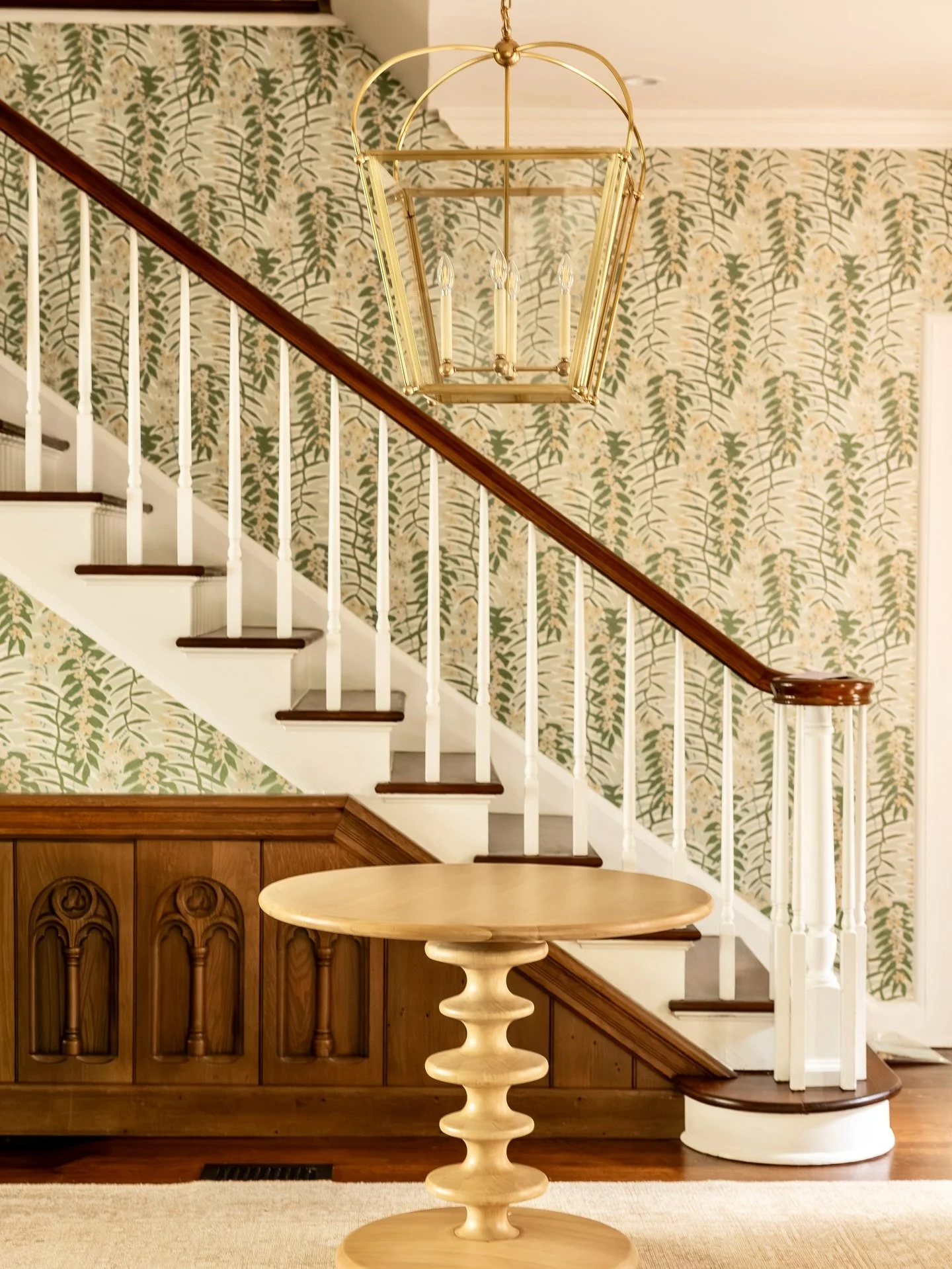Let your foyer do the talking! This 1920s home already had incredible bones and natural light, so we layered in this amazing floral wallpaper, statement light fixtures, a center table, and a rug to highlight its architecture, all while making the spa