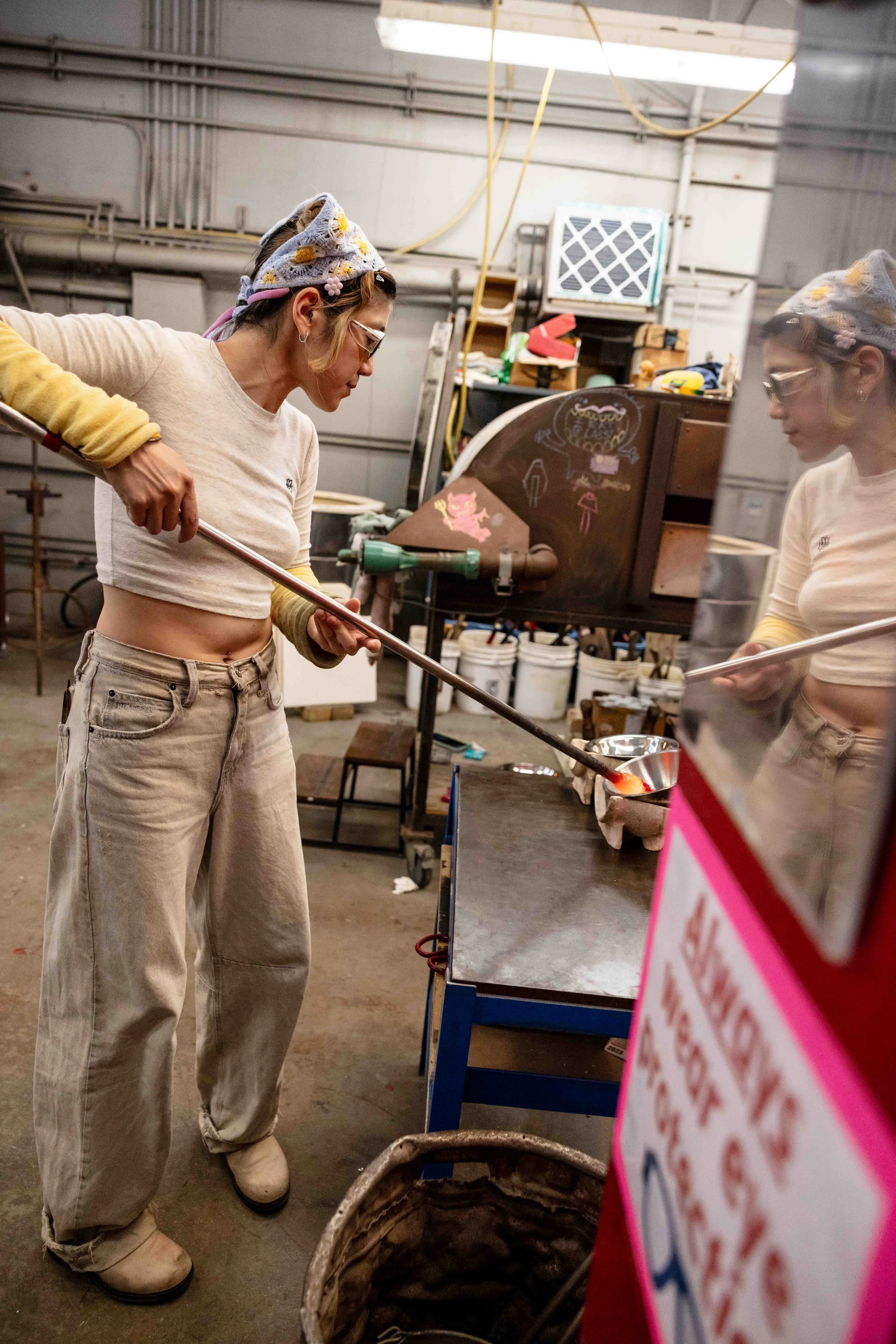 Haneul Park dips hot glass into bowls of frit (crushed colored glass), Friday, May 29, 2026.  