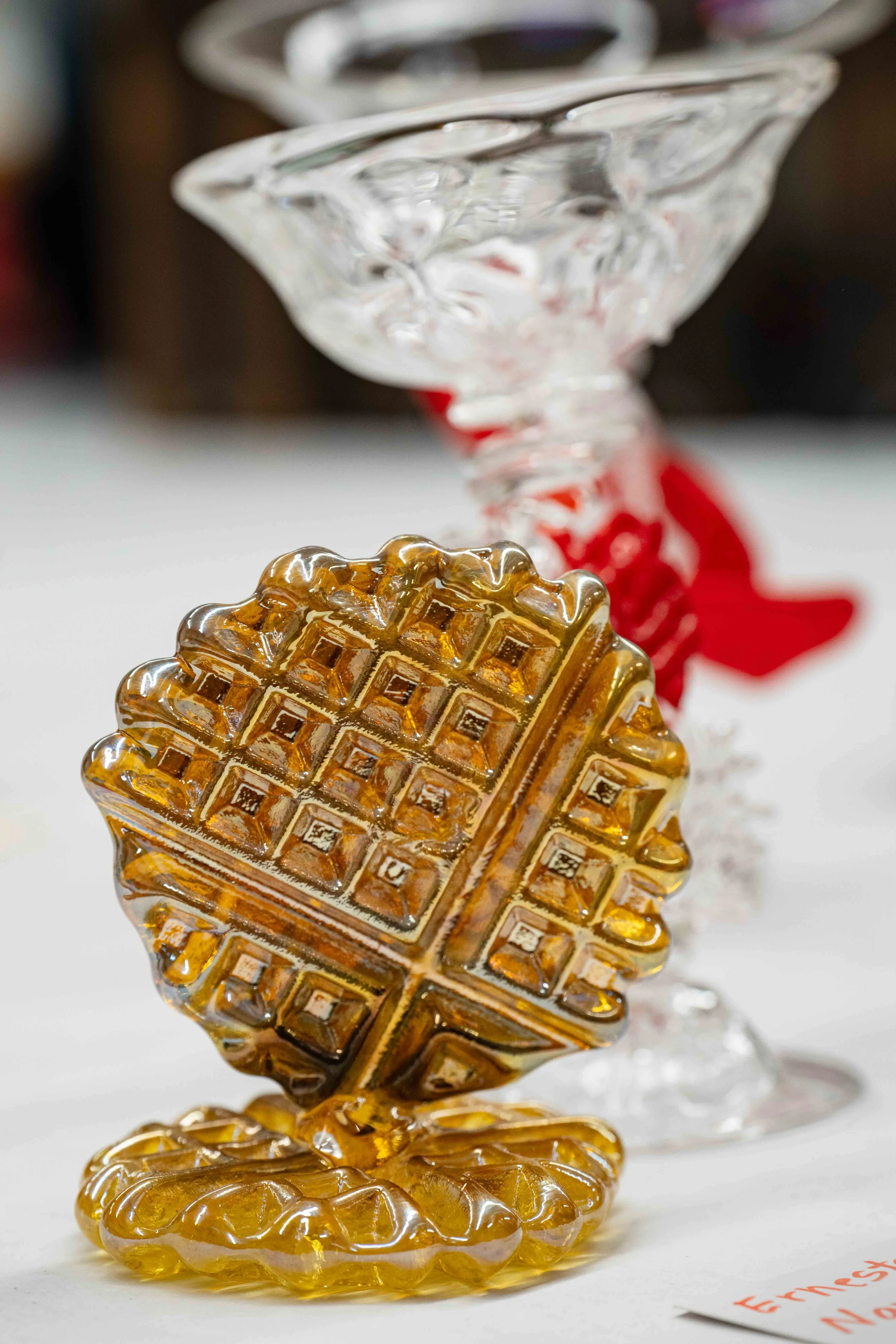  The "Golden Waffle," made by Andrew Berney using an actual waffle iron, and bestowed by the lab technicians as an award to Ernesto Navarro. Behind the waffle, two glass pieces by Navarro, Monday, June 8, 2026. 