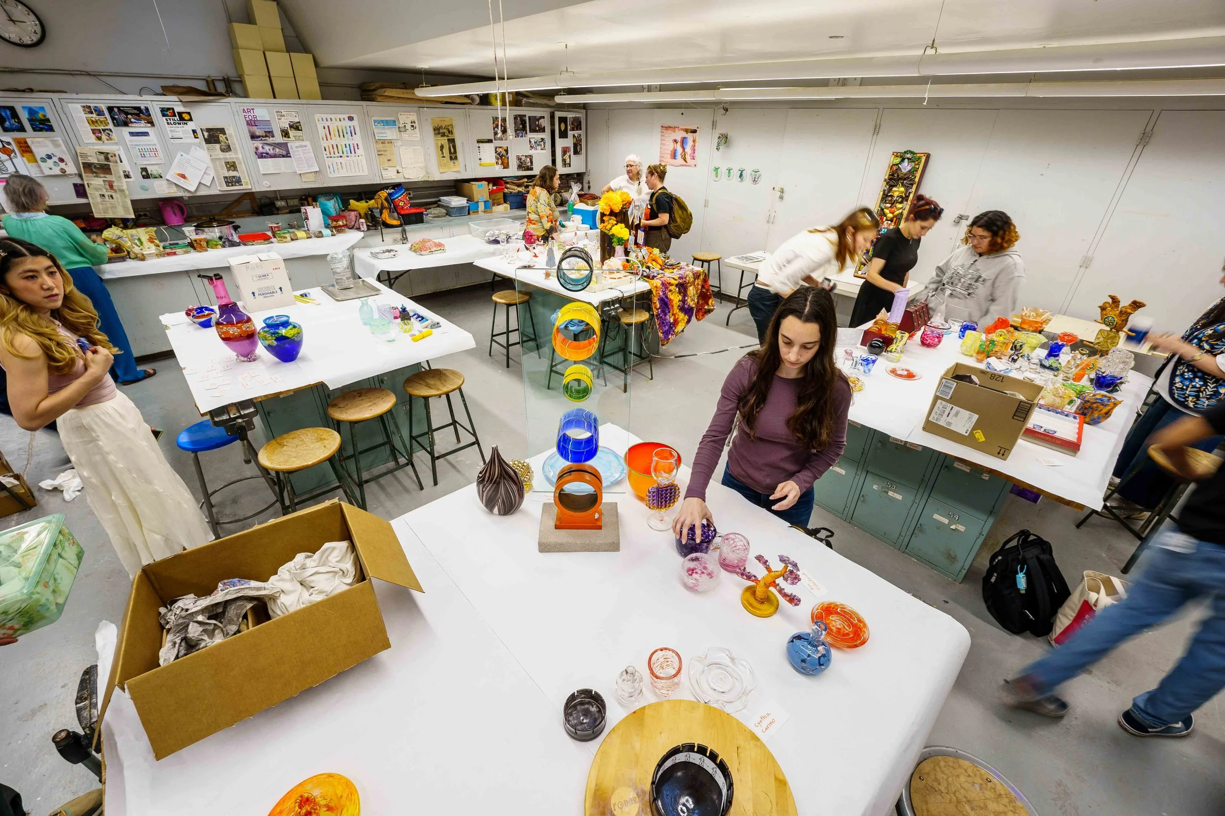  The spring glass sculpture class sets up final presentations on tables inside the glass studio, with student Haneul Park (left) and a colorful tower by laboratory technician Andrew Berney in the center, Monday, June 8, 2026. 