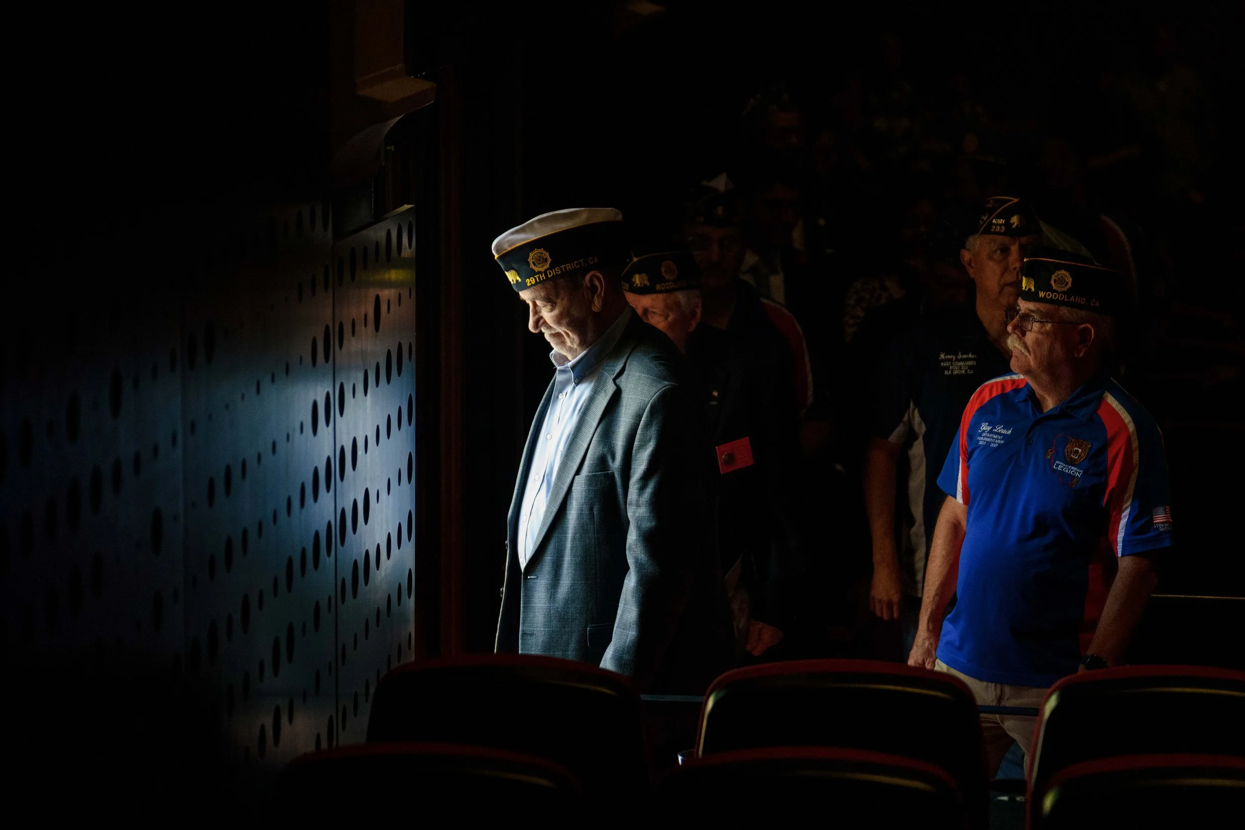  Vietnam War veteran David Graham (center) exits the theater alongside American Legion Past Department Parliamentarian Gary Leach (right) and other veterans. 