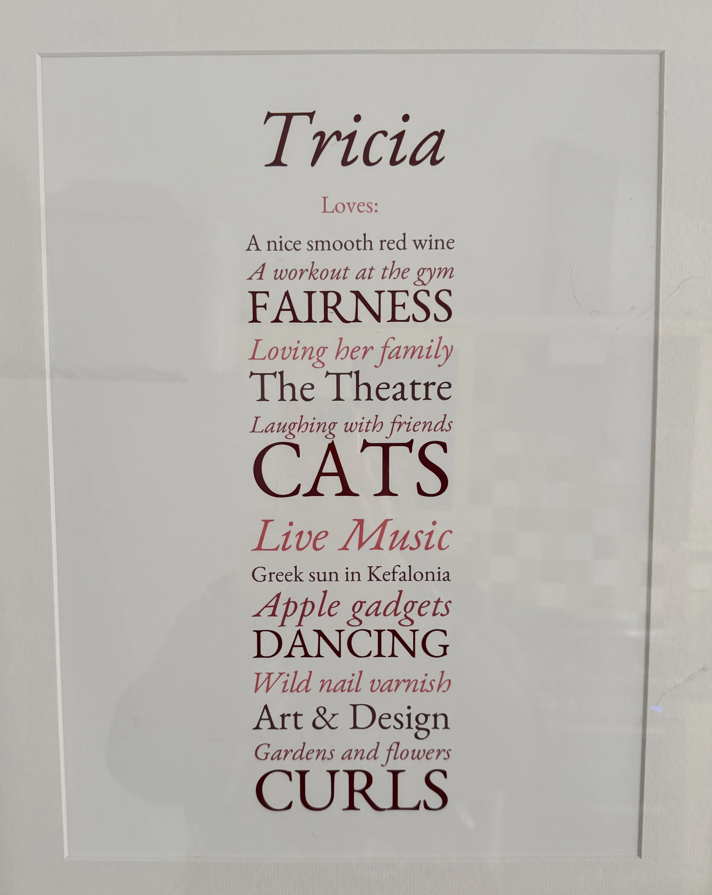Framed print titled "Tricia Loves:" listing personal interests in alternating text styles.