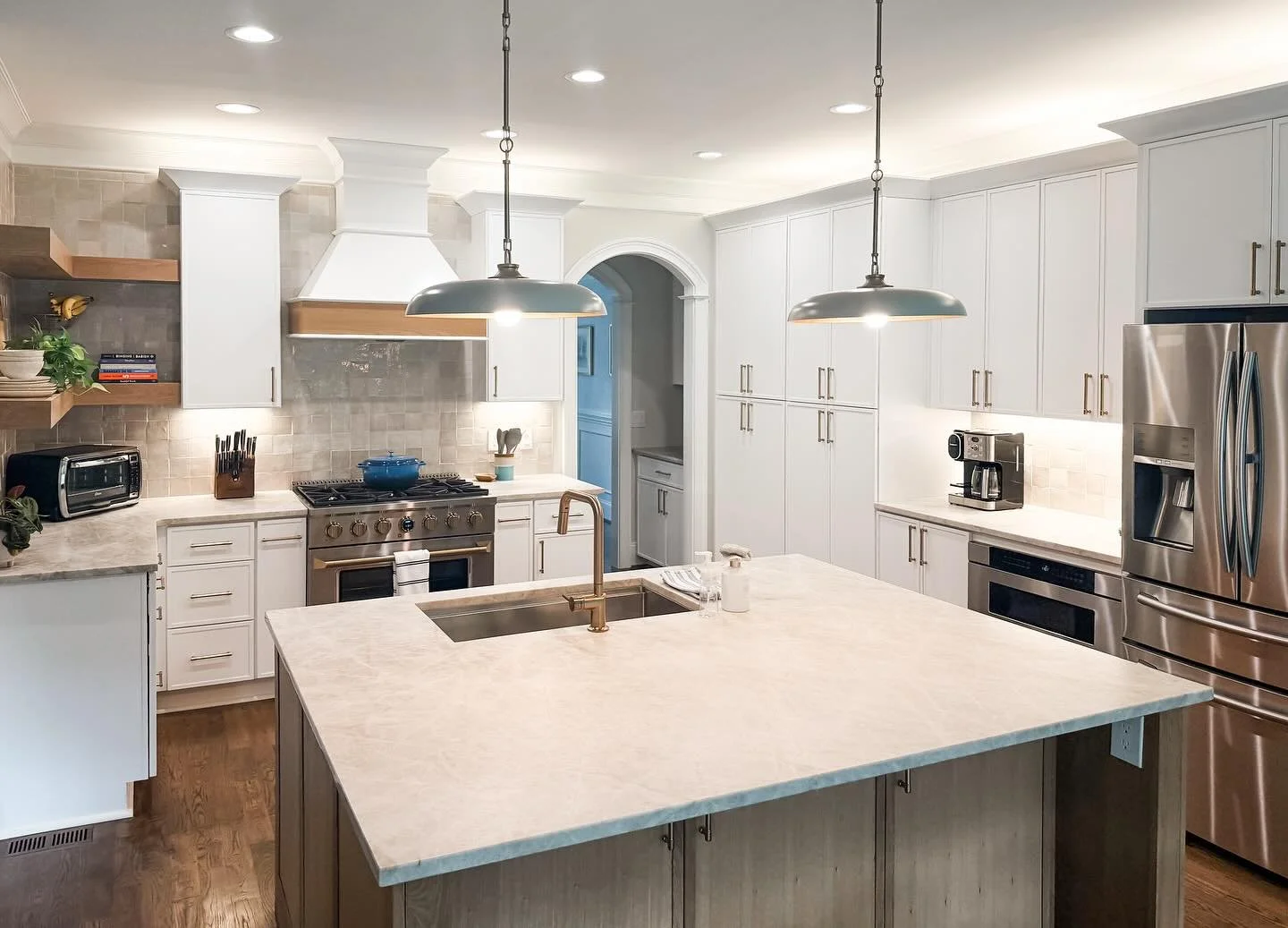 My clients dreamed of a kitchen made for gathering&mdash;and this remodel delivered! We designed a larger island perfect for entertaining, topped with gorgeous Taj Mahal countertops that set the tone for the whole space. Slim micro shaker cabinets pa