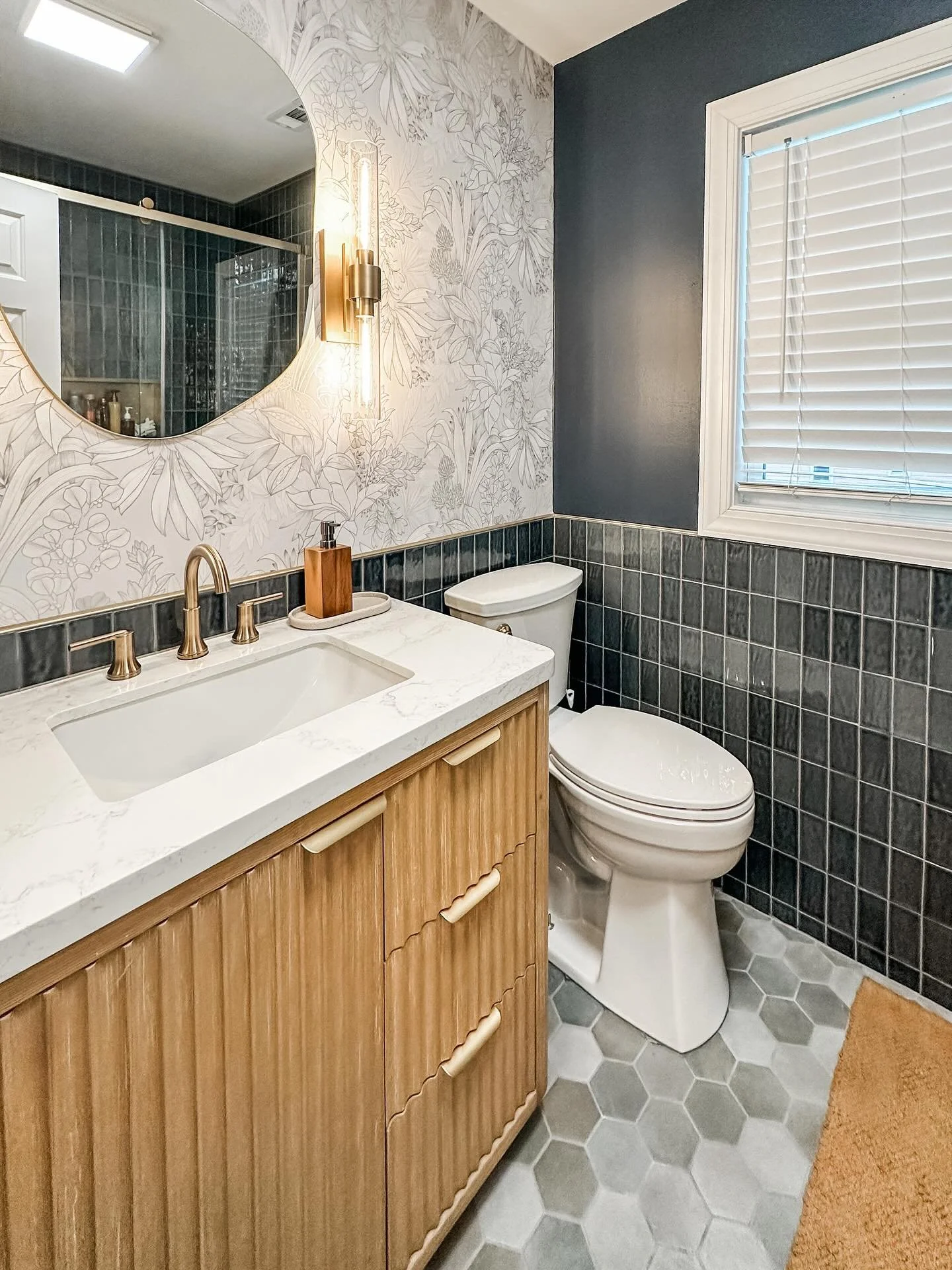 From splashes to sophistication: This bathroom was designed with two messy teen boys in mind&mdash;durable navy tile, a full tile surround, and statement sconces that elevate the look while standing up to everyday chaos. The best compliment? The boys