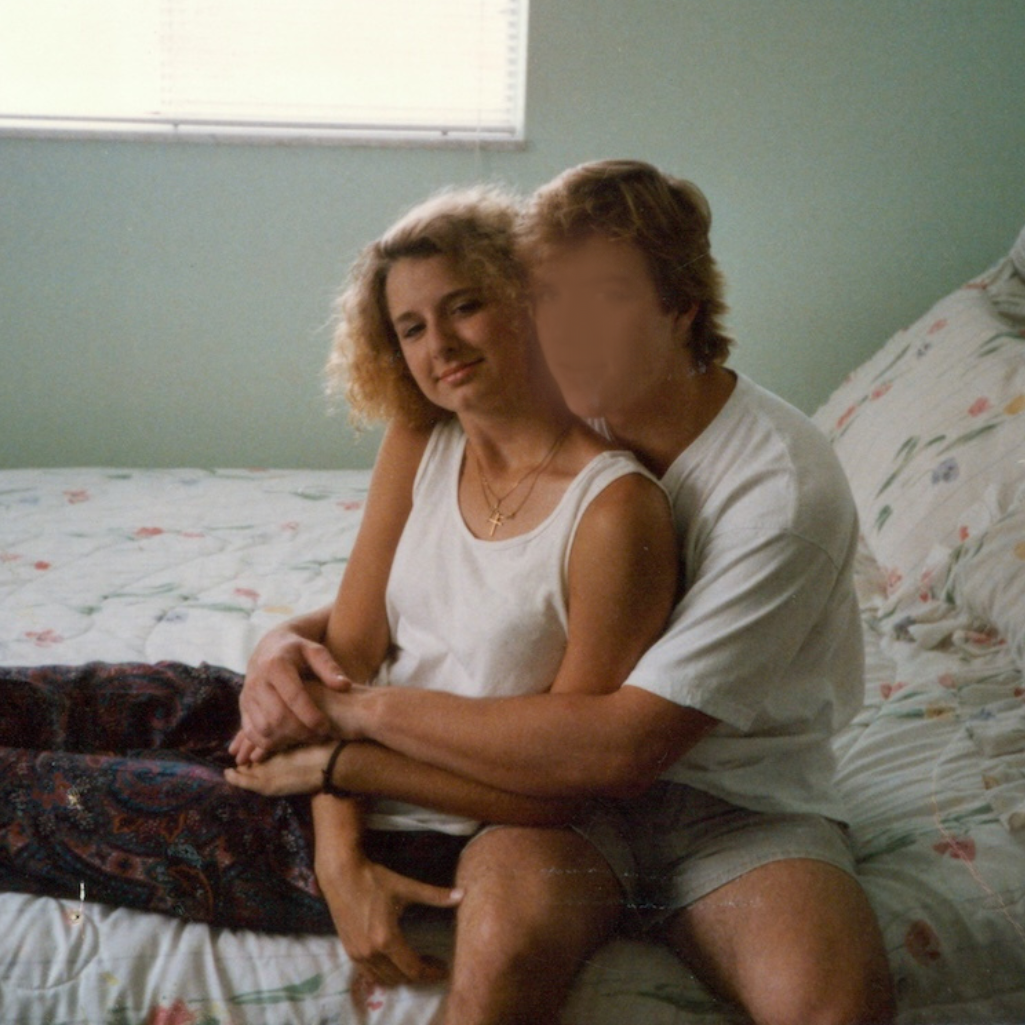 old photo of SJ Hodges and John sitting on a bed holding eachother