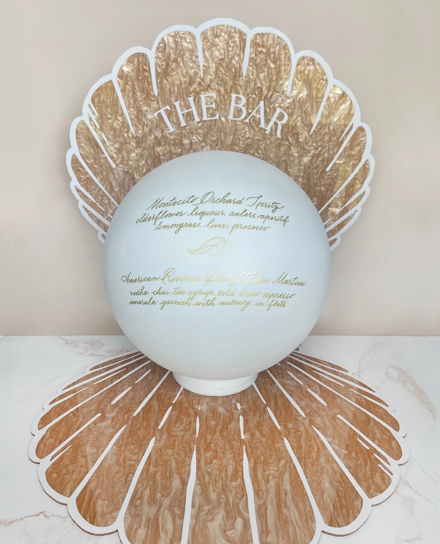 An oversized clamshell, crafted from pearlescent acrylic, framed a luminous &ldquo;pearl&rdquo; inscribed in gold calligraphy with the evening&rsquo;s cocktails. A sculptural centerpiece that was as functional as it was unforgettable.
.
Planning &amp