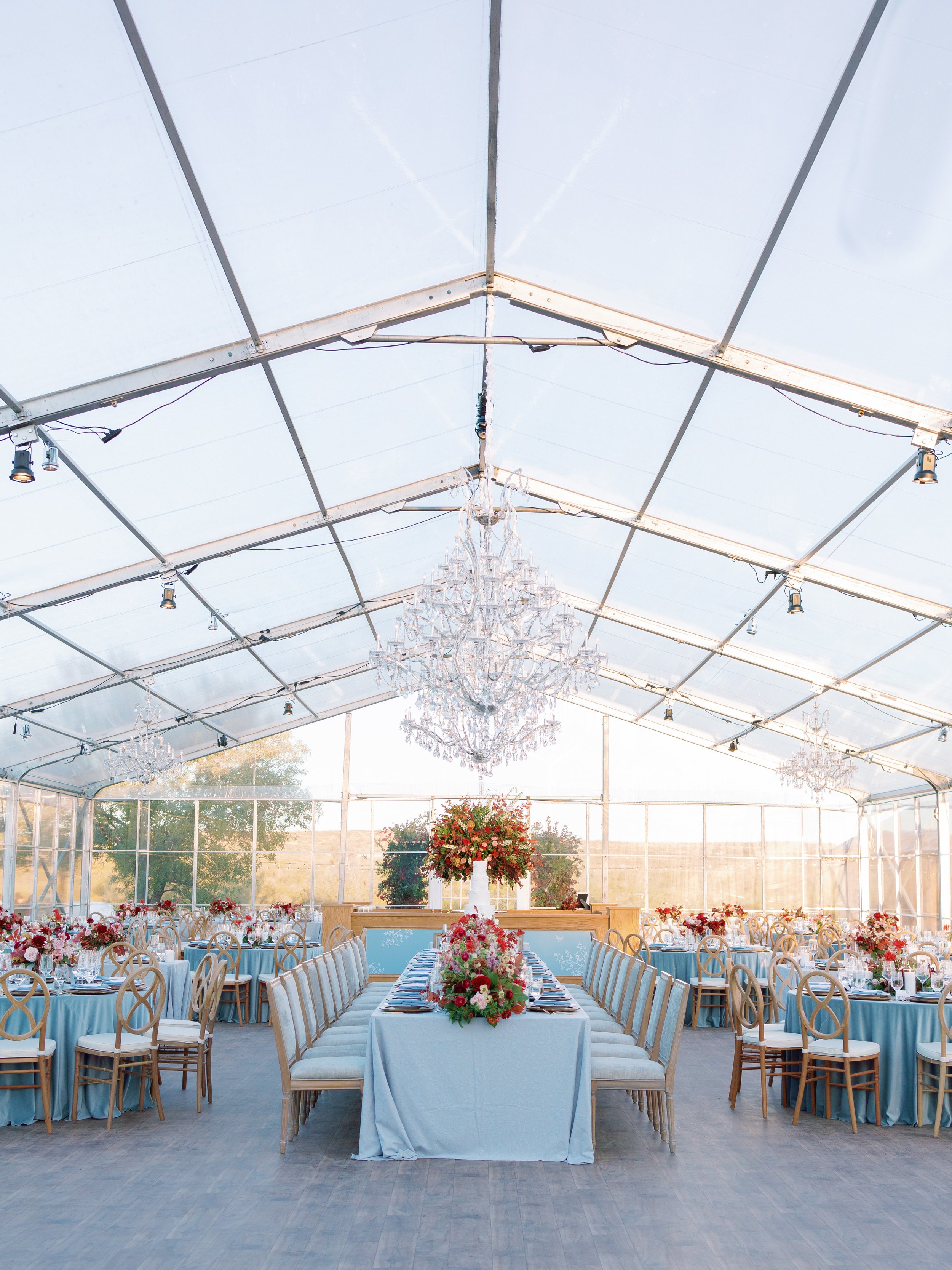 Clear Top Tent Private Estate Ranch Wedding Reception Entrance with Red and Burgundy Florals, Blue Linens and Chandeliers