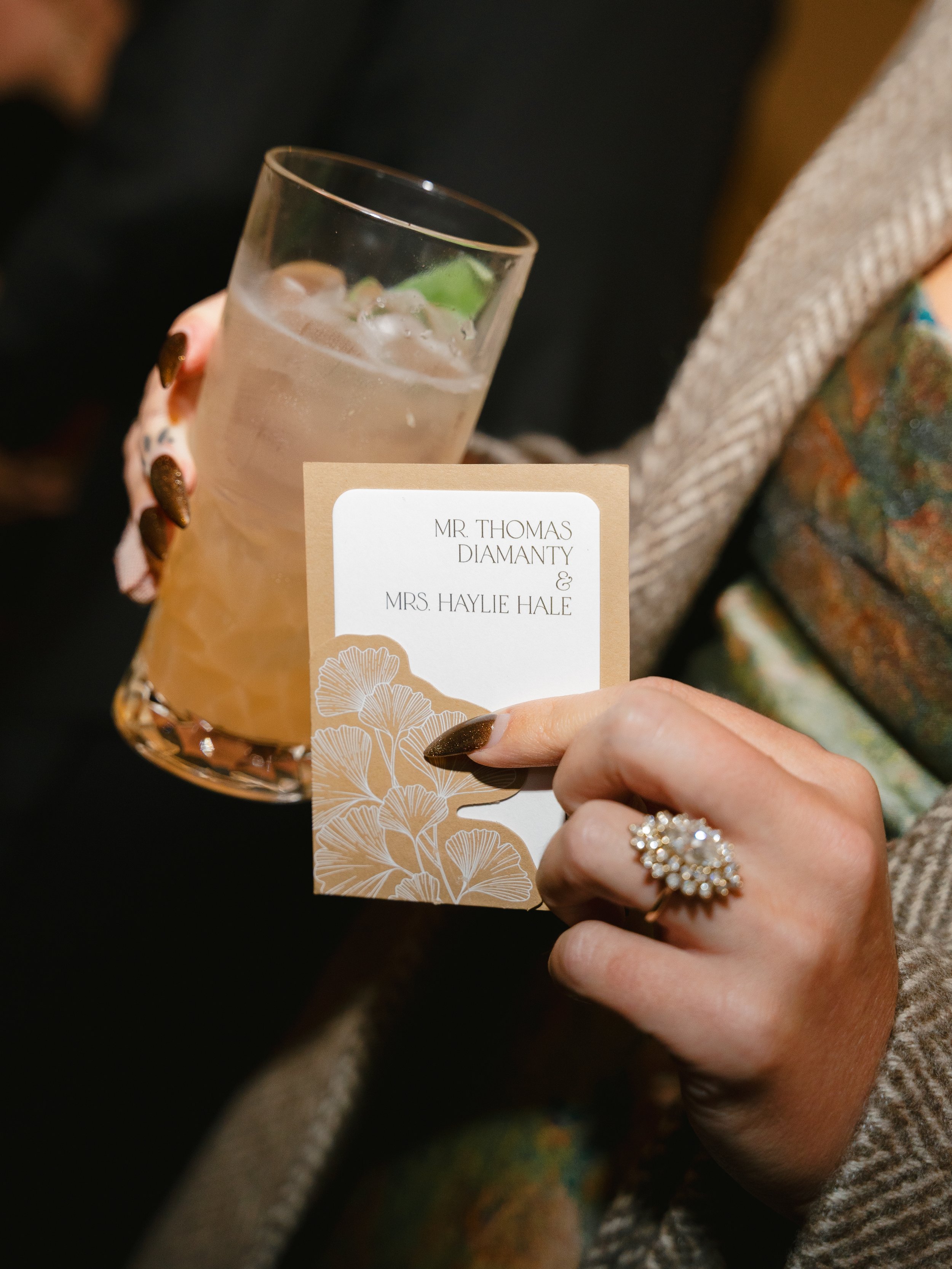Guest Holding Cocktail and Die Cut Escort Card Pockets with Ginko Leaves at Union Station in Washington D.C.