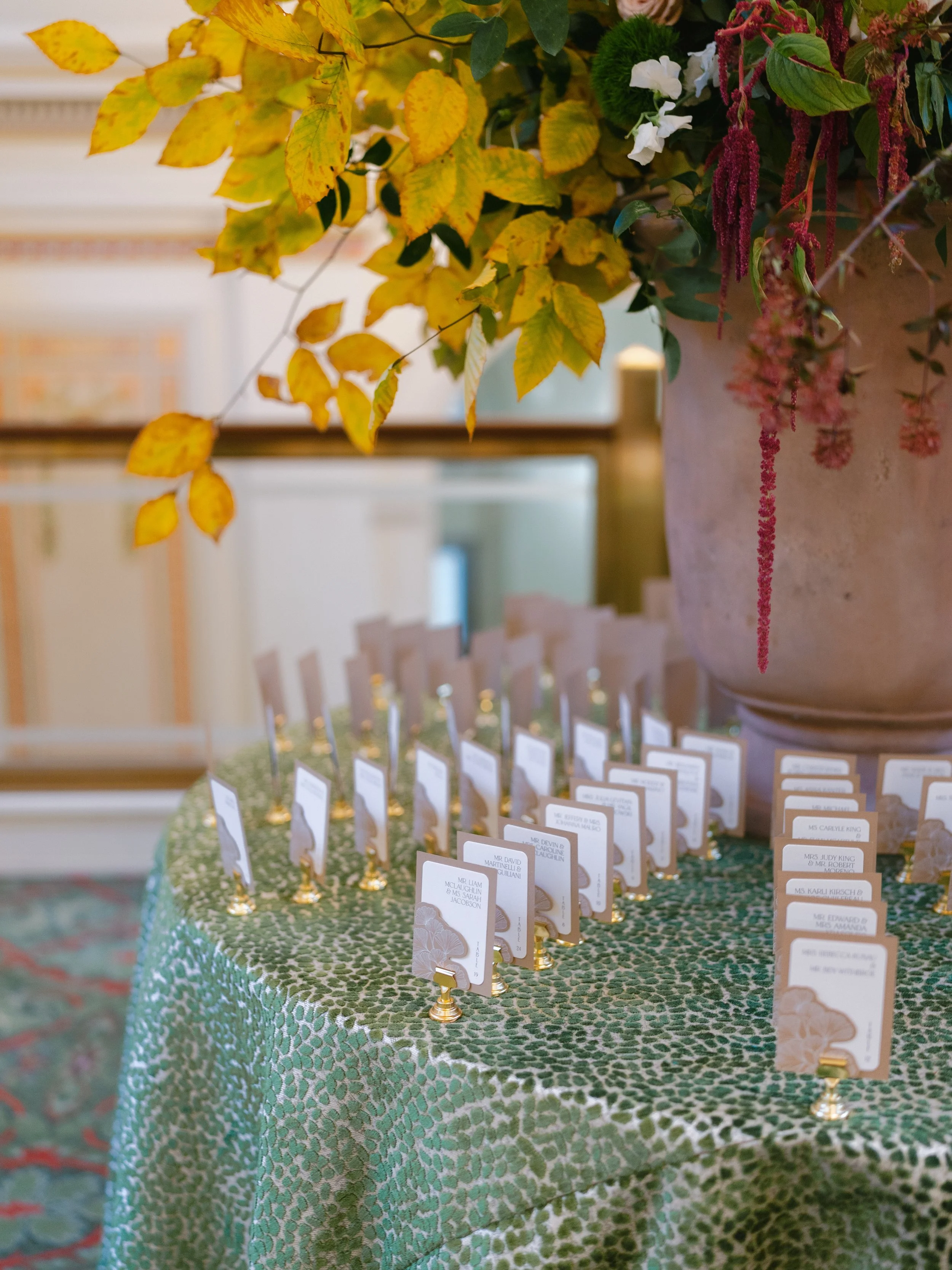 Close Up of Die Cut Escort Card Pockets with Ginko Leaves at Union Station in Washington D.C. on Table with Floral Arrangement
