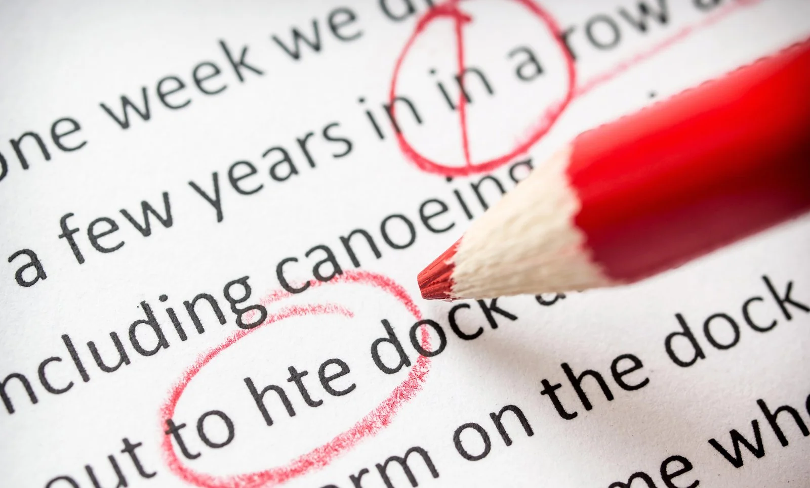 Close-up of a red pencil highlighting the phrase "to hte dock" in a printed document with red pen markings.