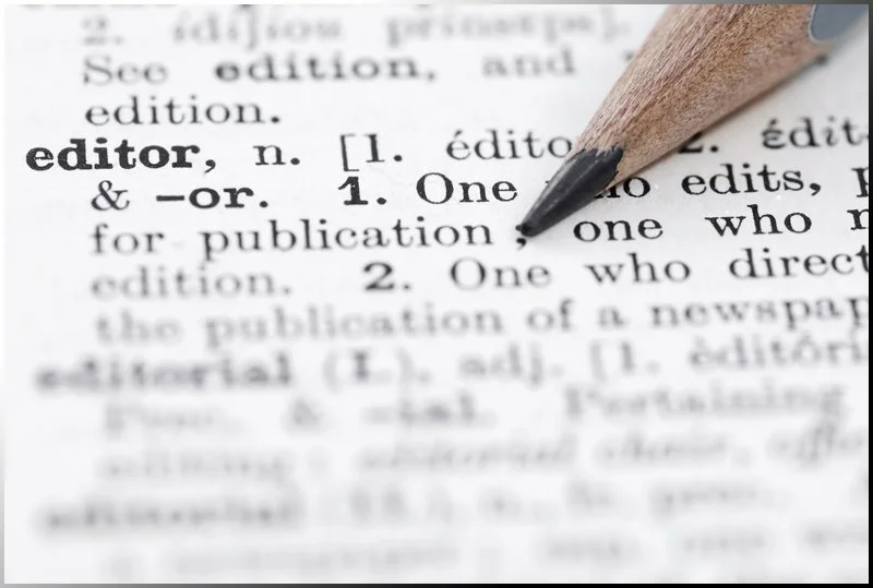 Close-up of a dictionary page with a pencil pointing to the word 'editor'.