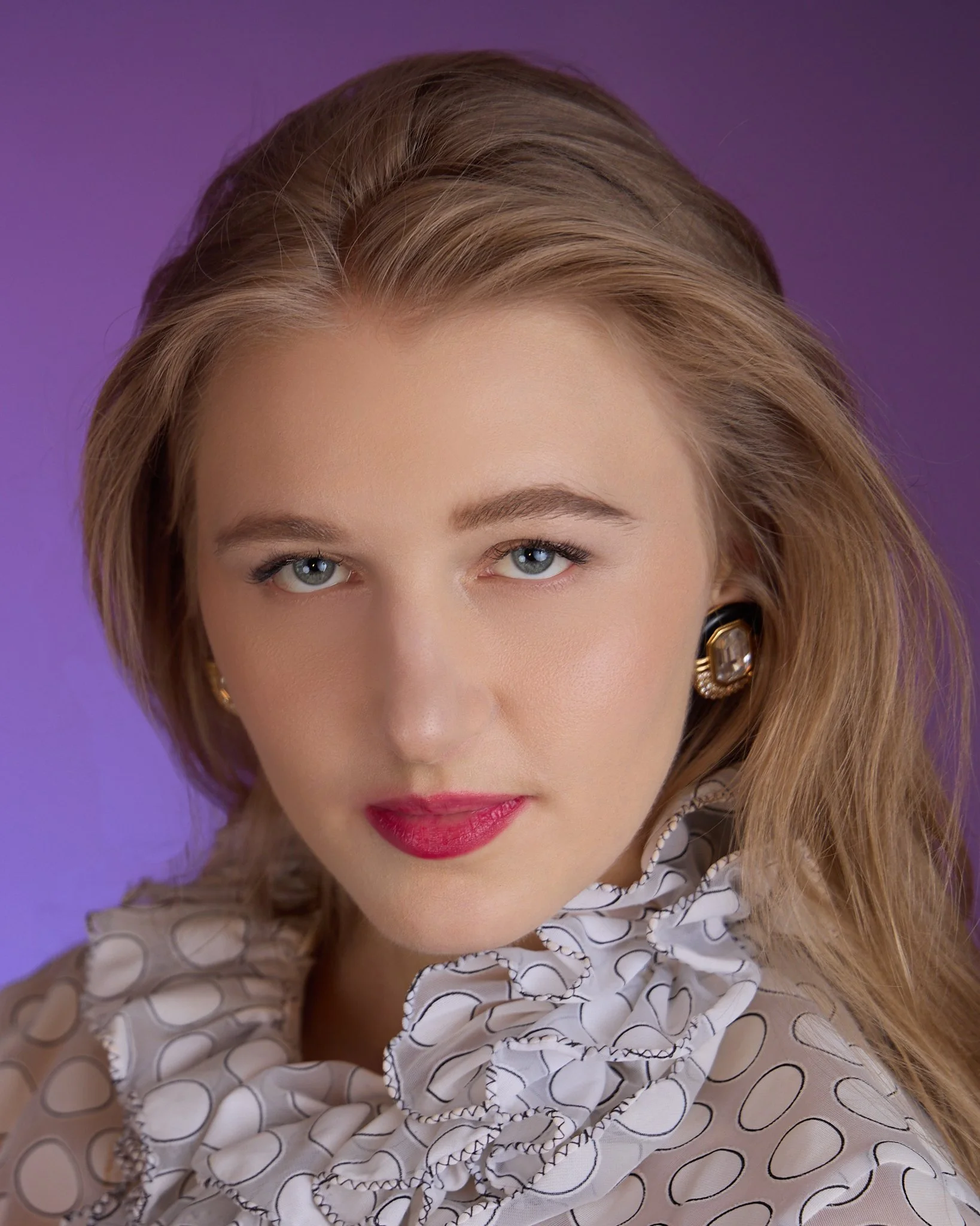 Jacqui de Jong in a vintage ruffled blouse against a violet background
