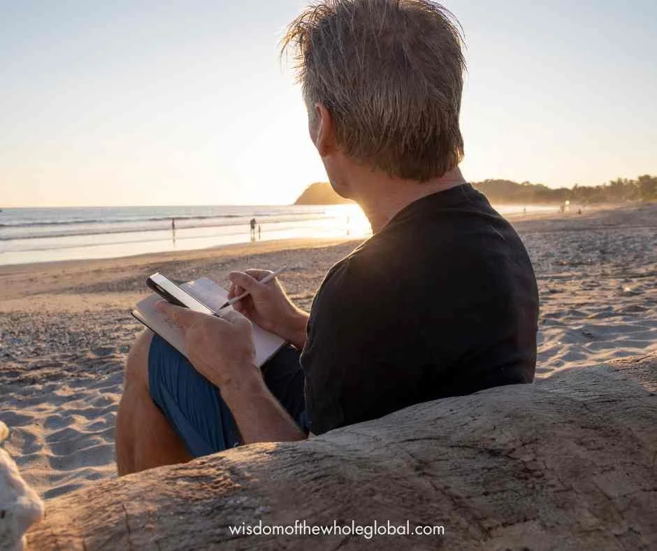 man journaling at the beach