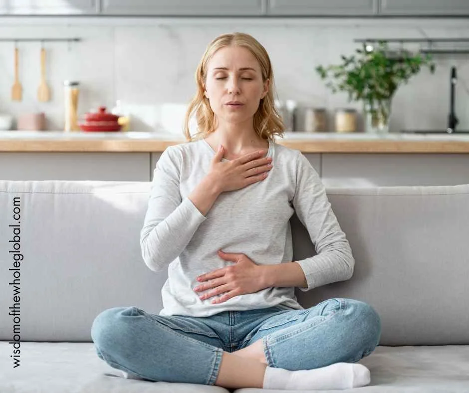 A seated woman using breathing techniques