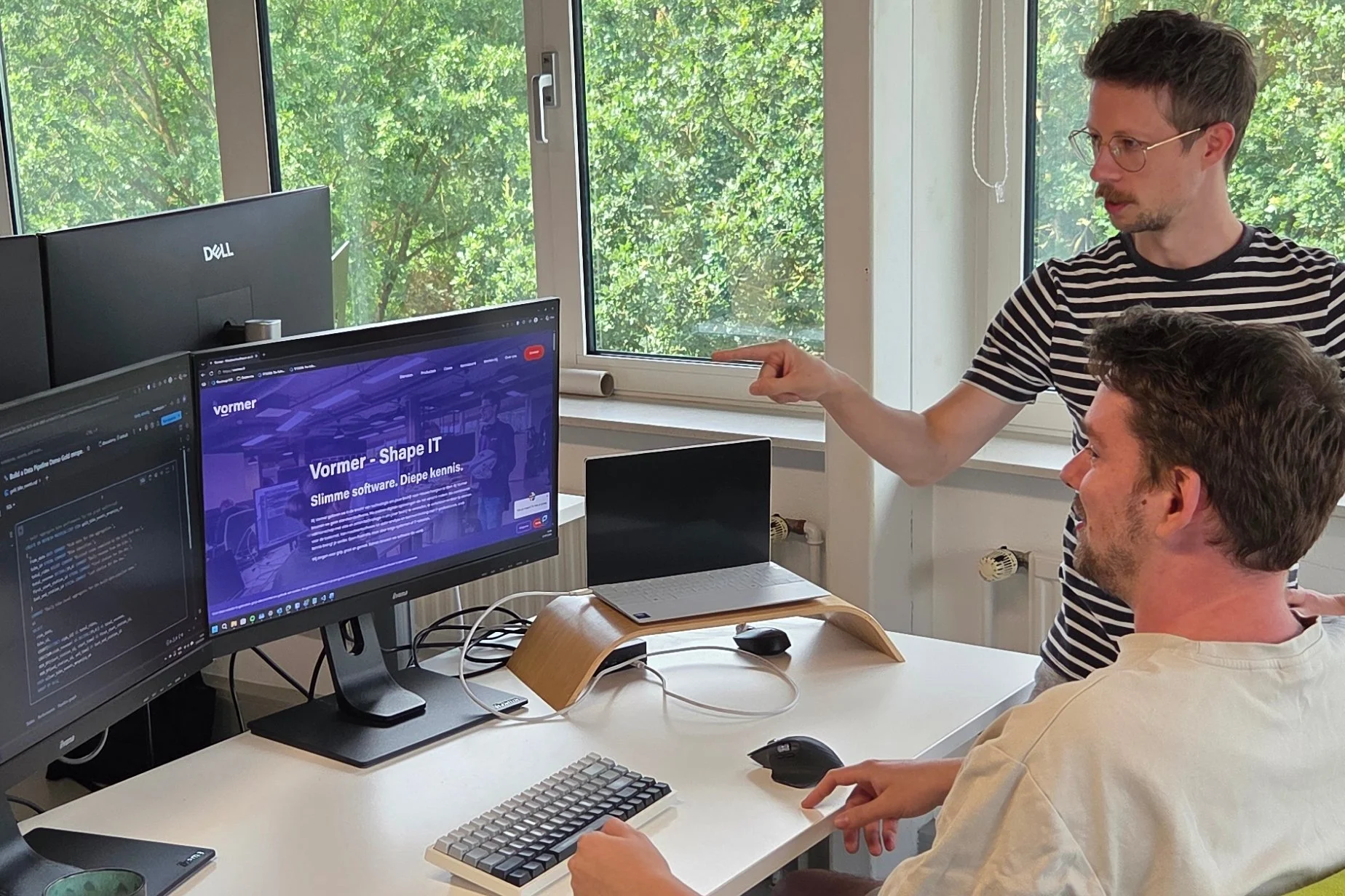 Collega's Wolter en Ron bestuderen iets op een scherm