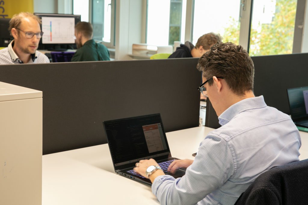 Collega kijkt naar een codescherm