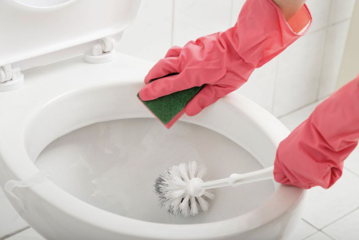 Toilet cleaning with pink gloves concept