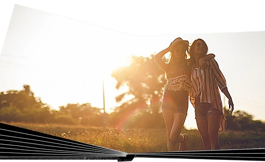 Two women walking outdoors during sunset, smiling and enjoying each other's company.