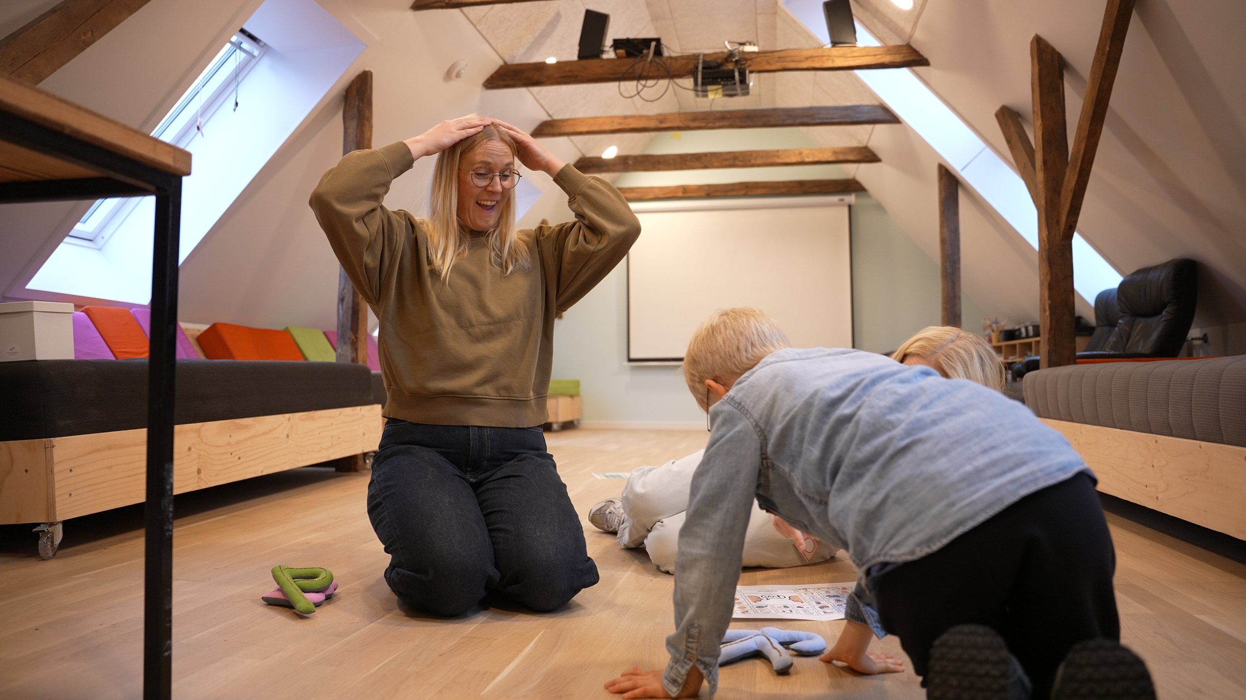 En voksen og et barn bruger tegn og kropsbevægelser i en fælles aktivitet.
