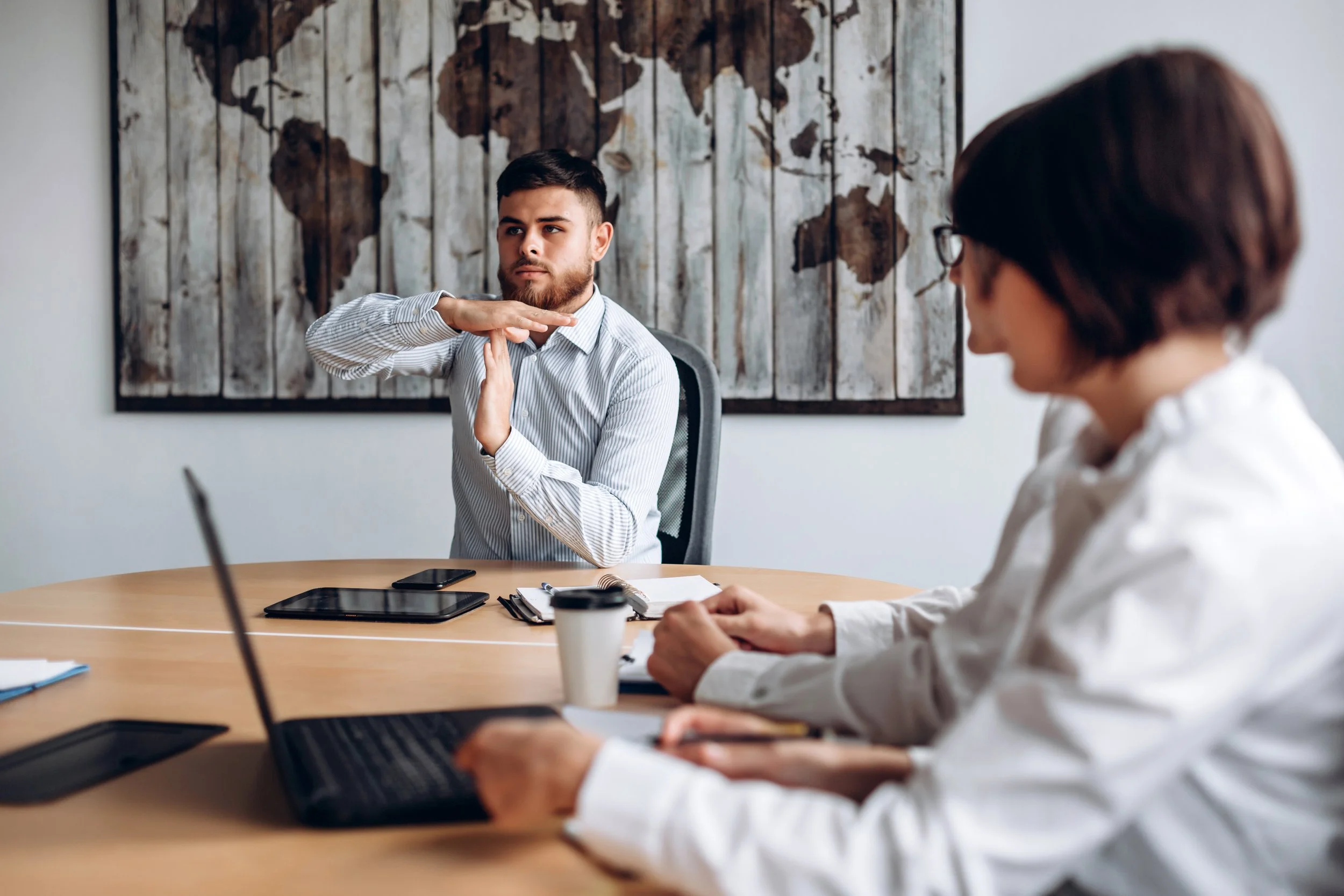 office worker holds his hand in shape of a T
