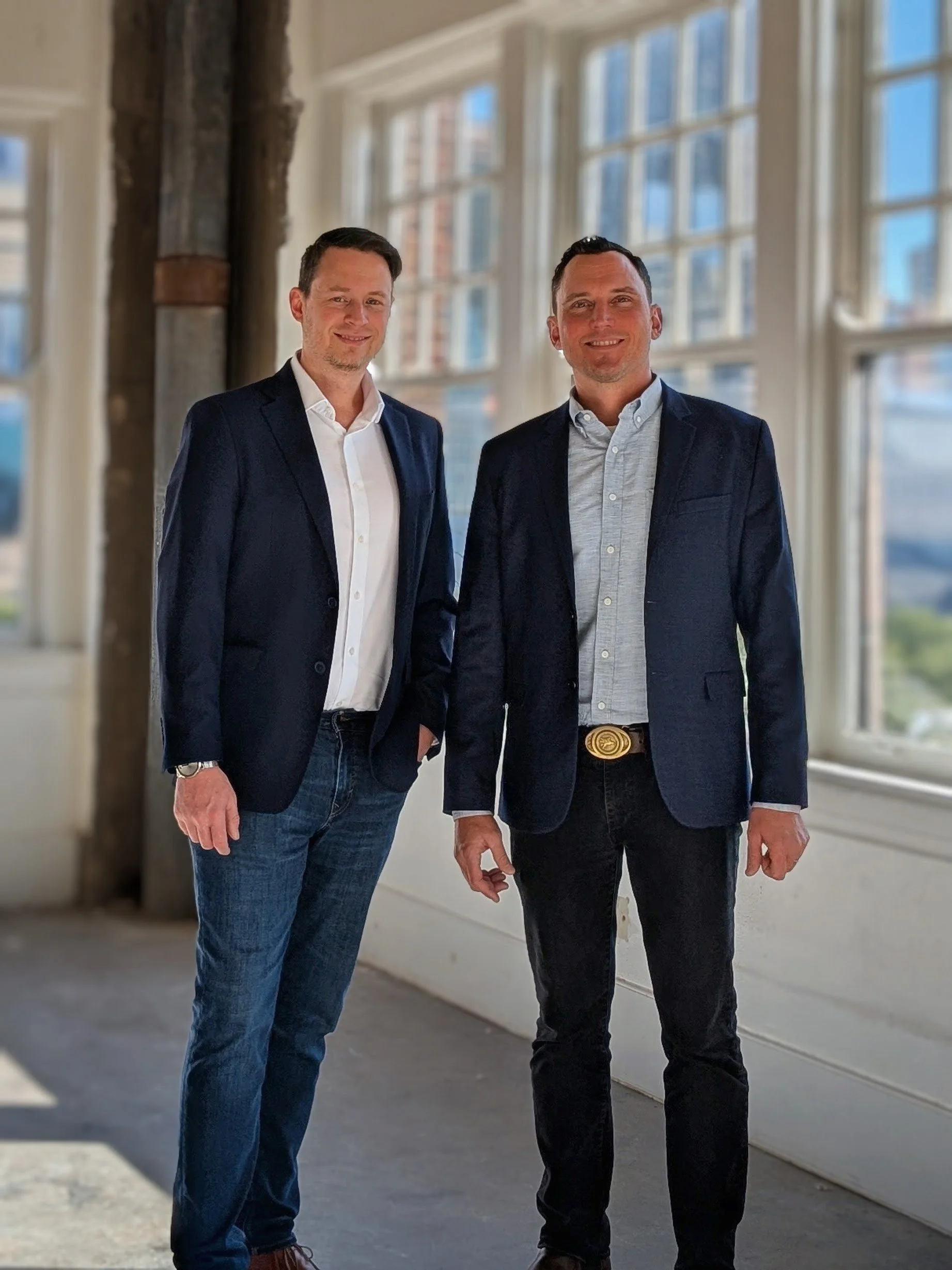 Two Center Design team members stand in a bright, modern healthcare design setting, representing the firm's leadership and client-focused architectural approach.