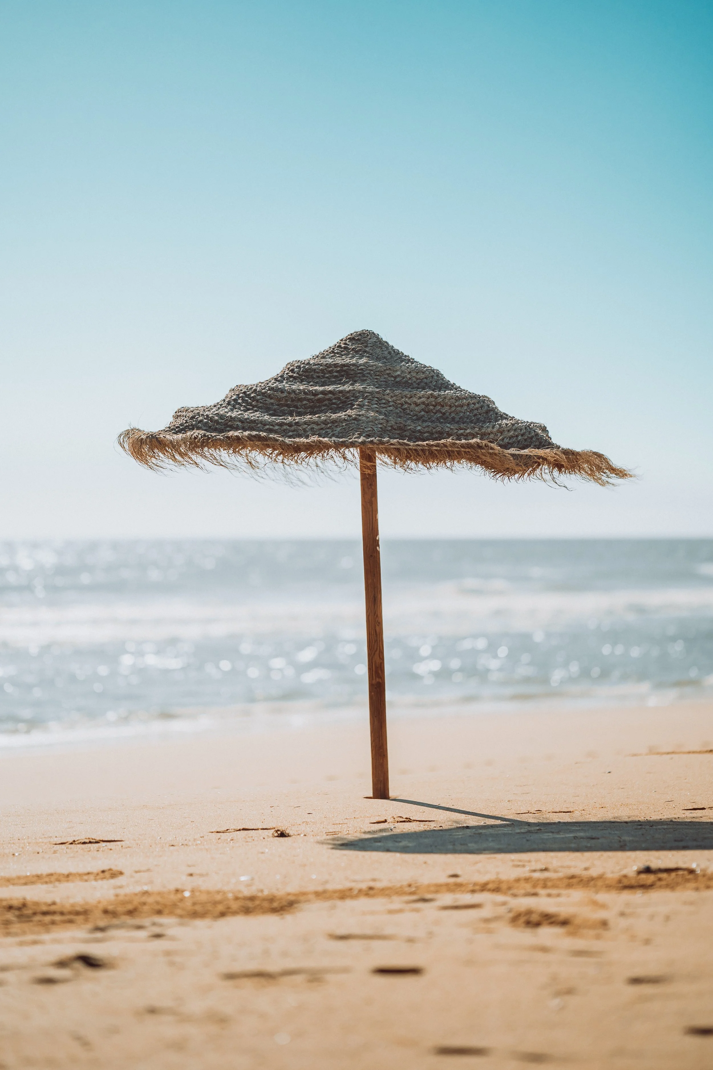 Tropical parasol on a beach with blue sky