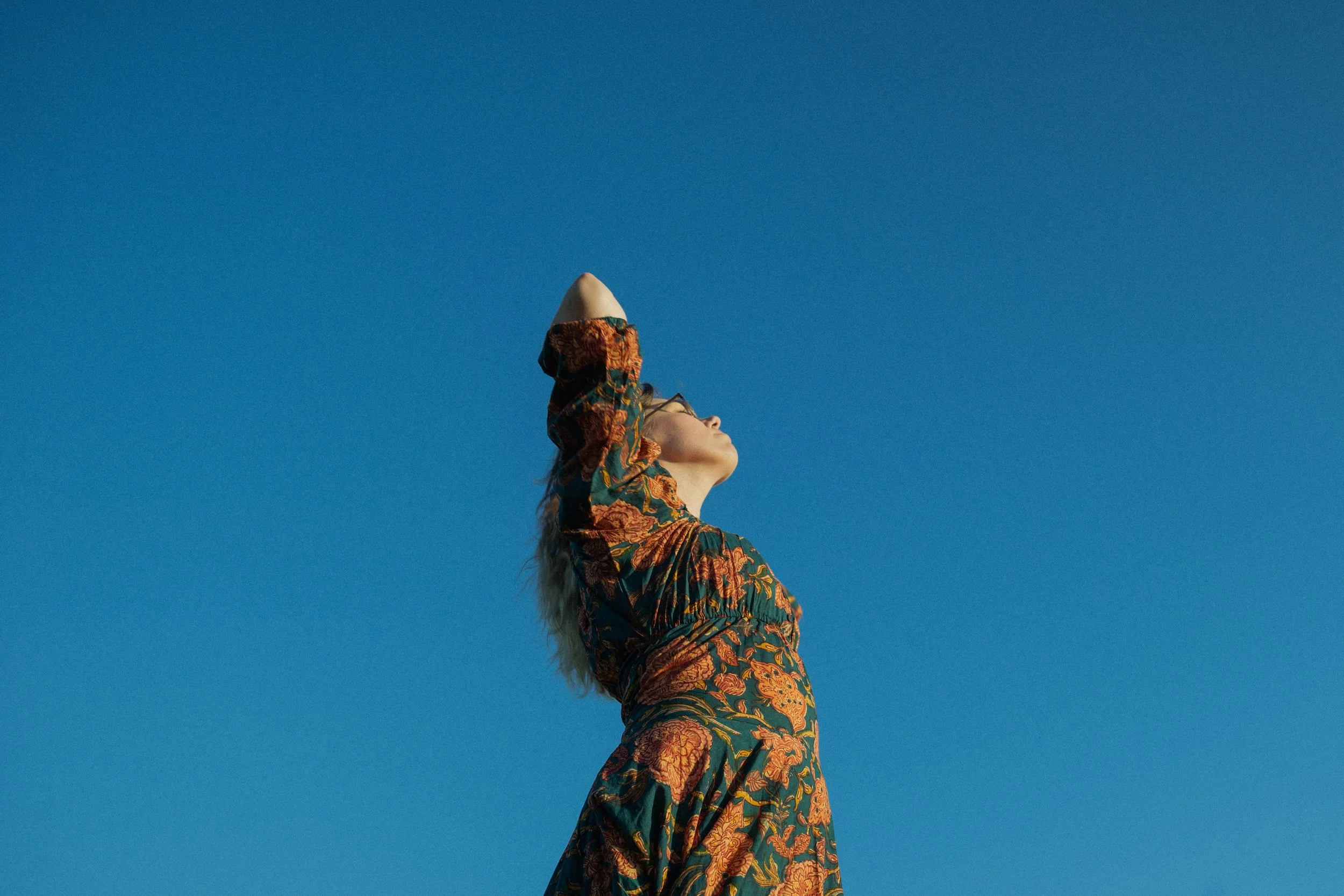 Girl in dress in front of blue sky