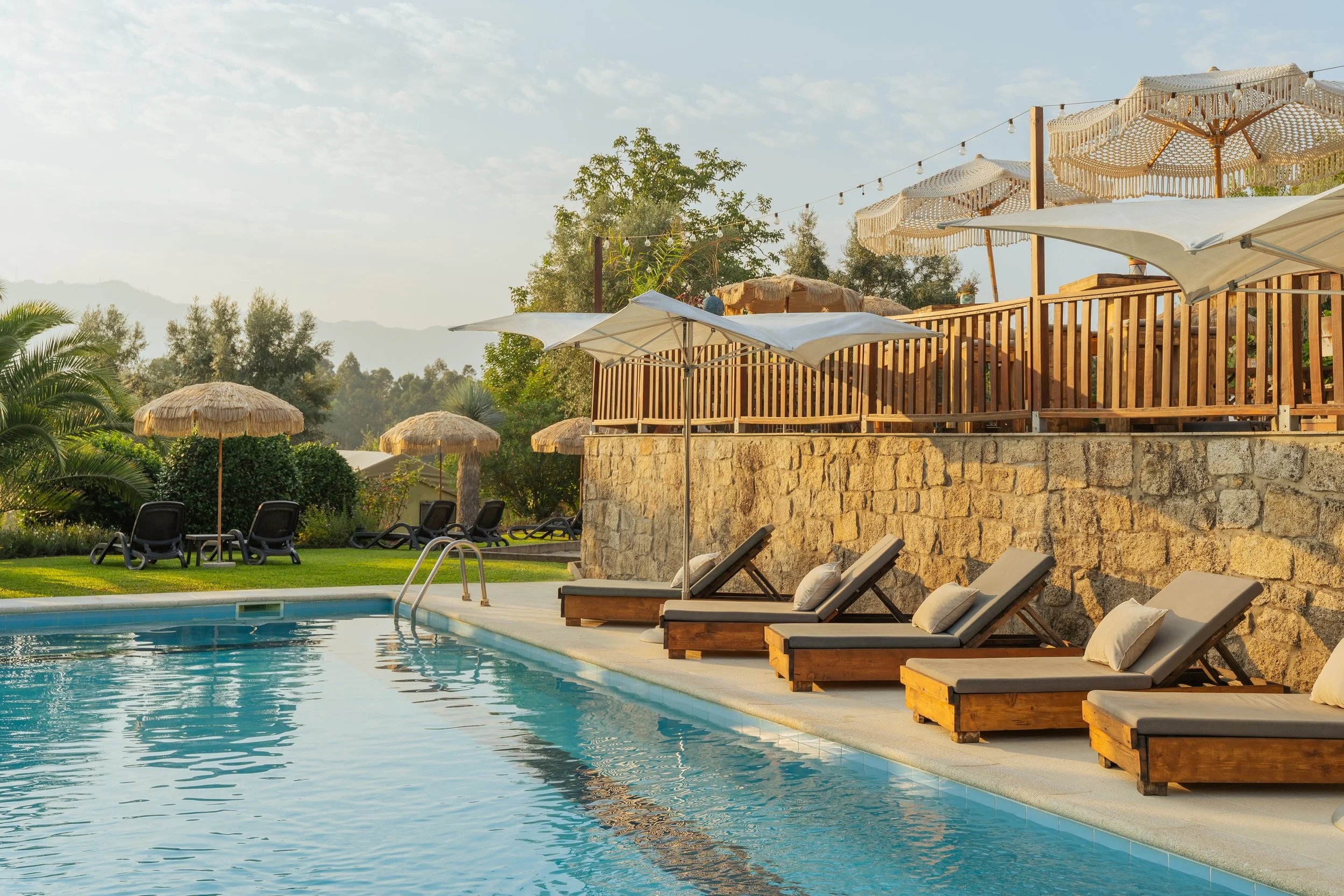 Beds next to luxury swimming pool with greenery