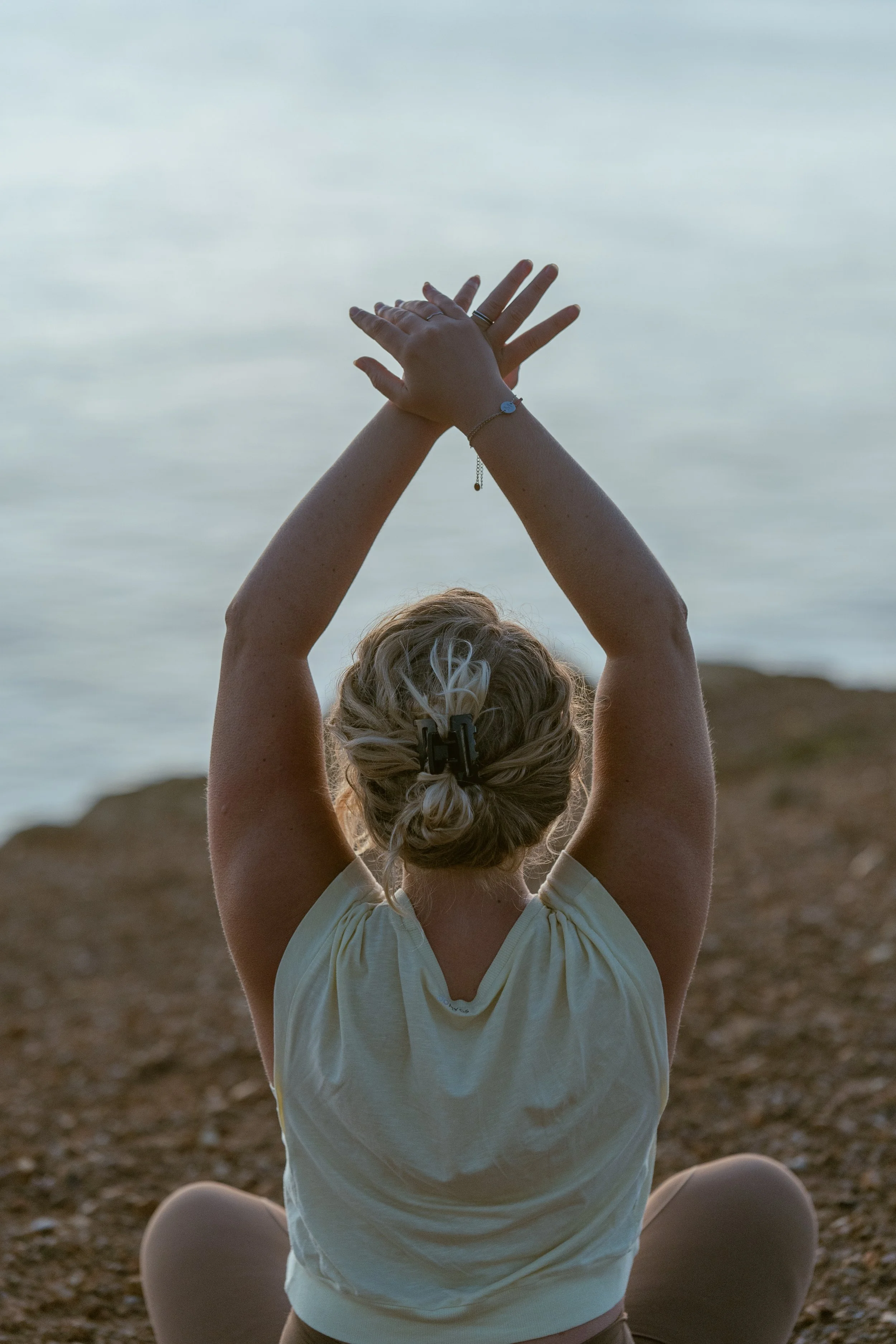 Girl doing yoga on a cliff