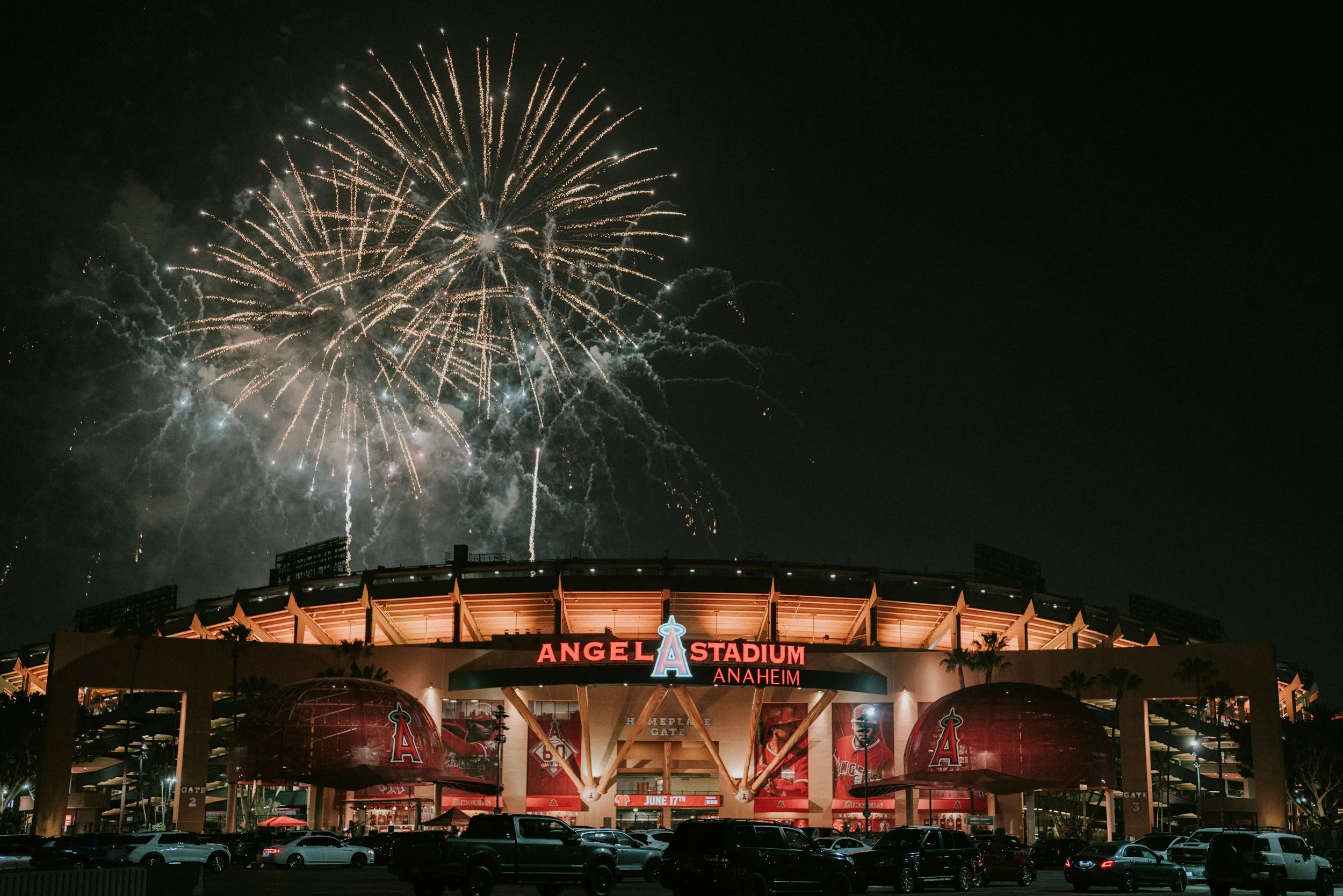 Nighttime view of Angel Stadium in Anaheim with fireworks lighting up the sky above.