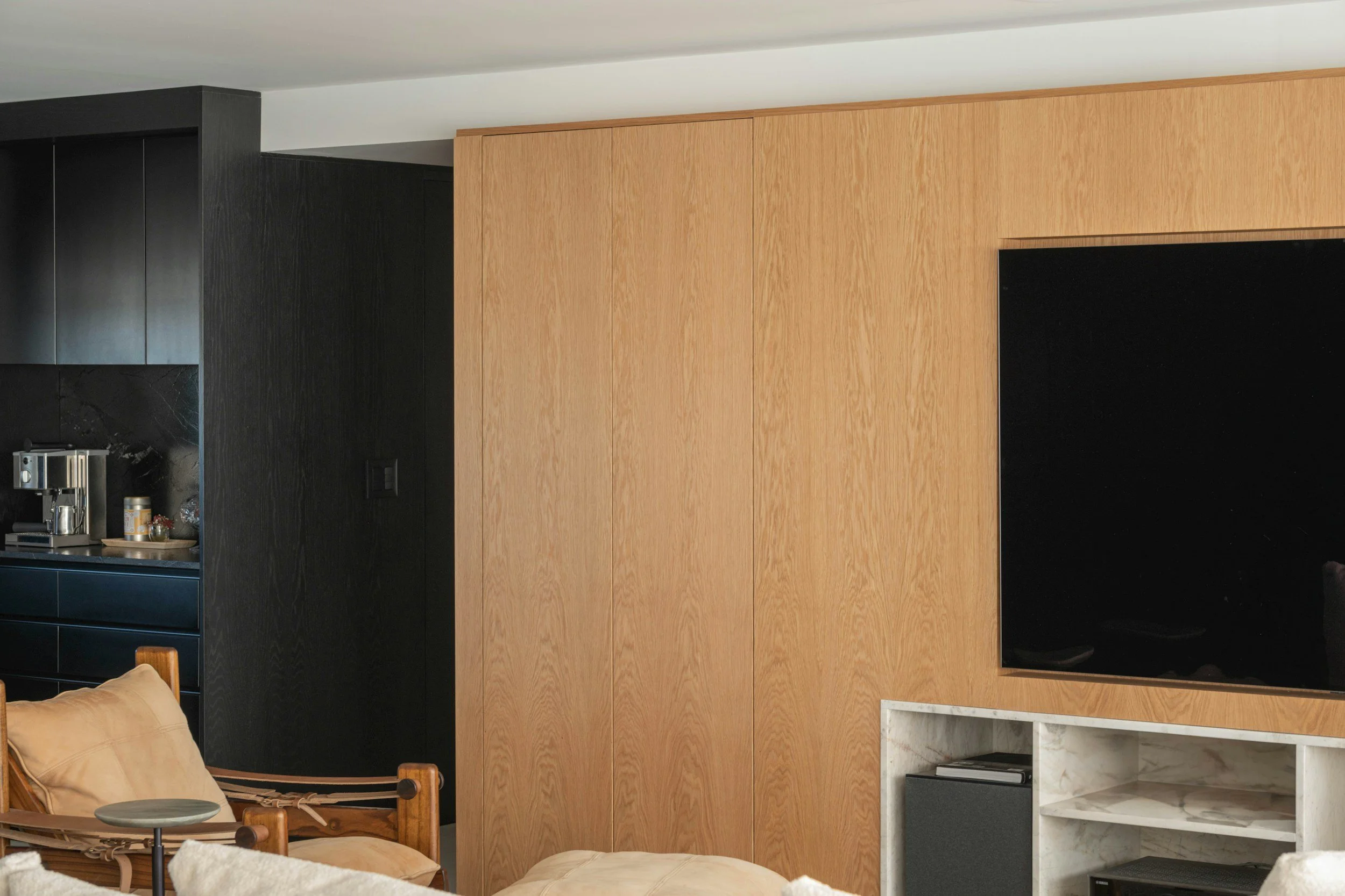 Modern living room with a large flat-screen TV mounted on a wood-paneled wall in orange county