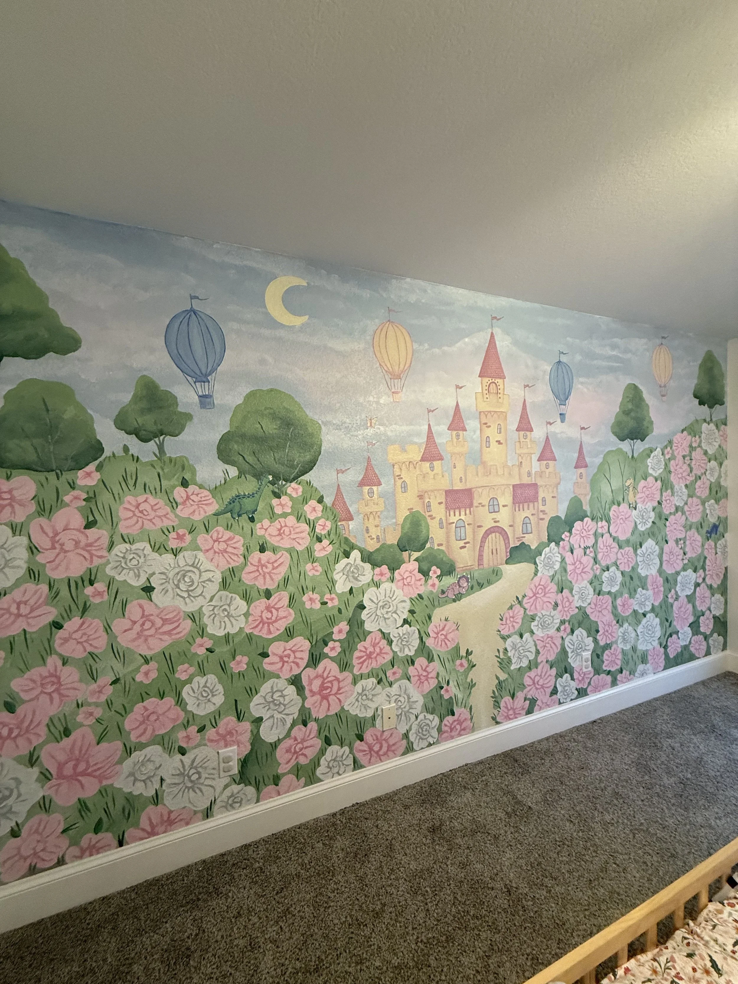 Colorful castle mural with pink flowers, green trees, blue and orange hot air balloons, and a crescent moon in the sky.