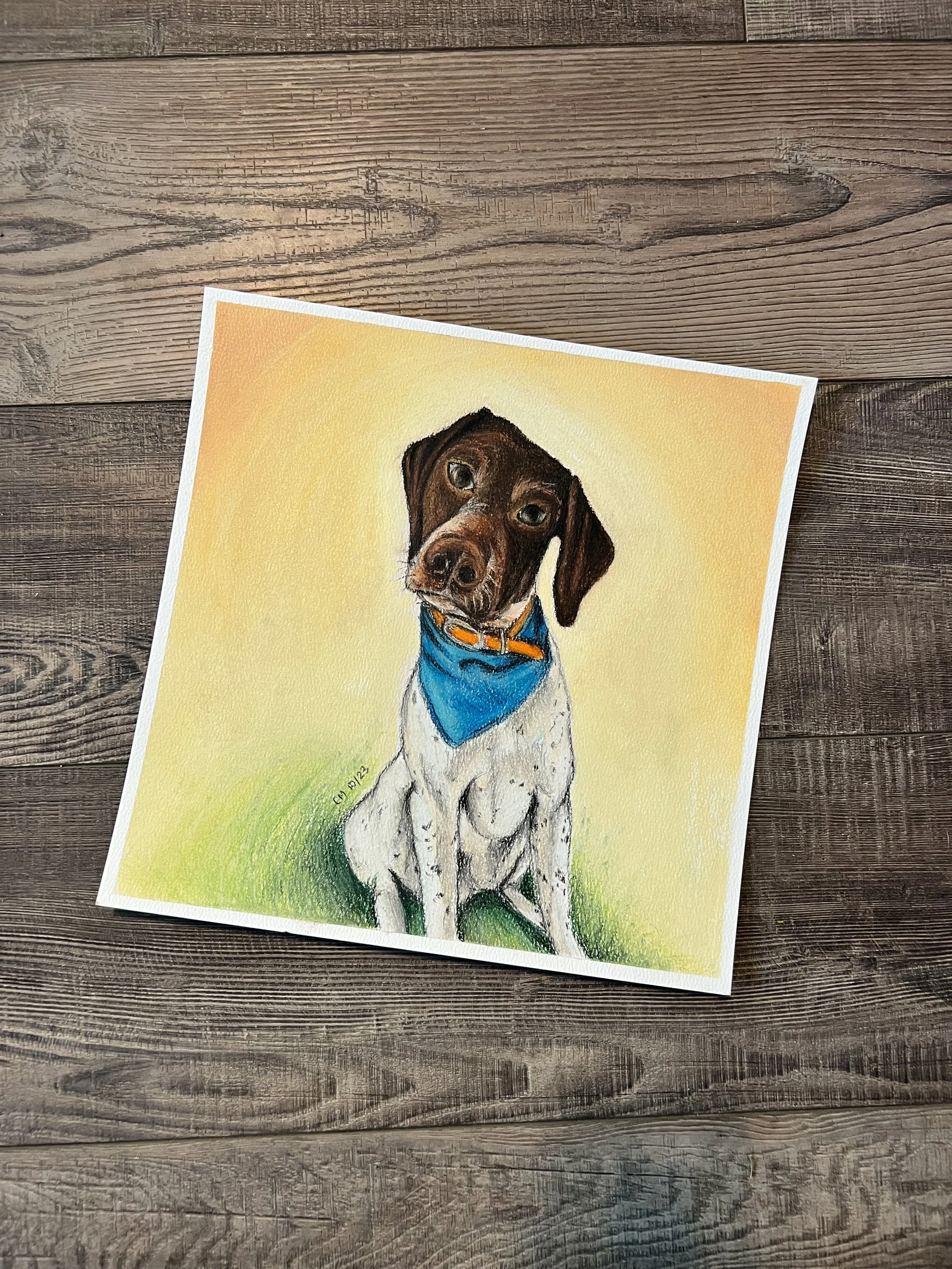 A colorful painting of a dog with a brown head and white body, wearing a blue bandana around its neck, sitting on grass with a light yellow background.