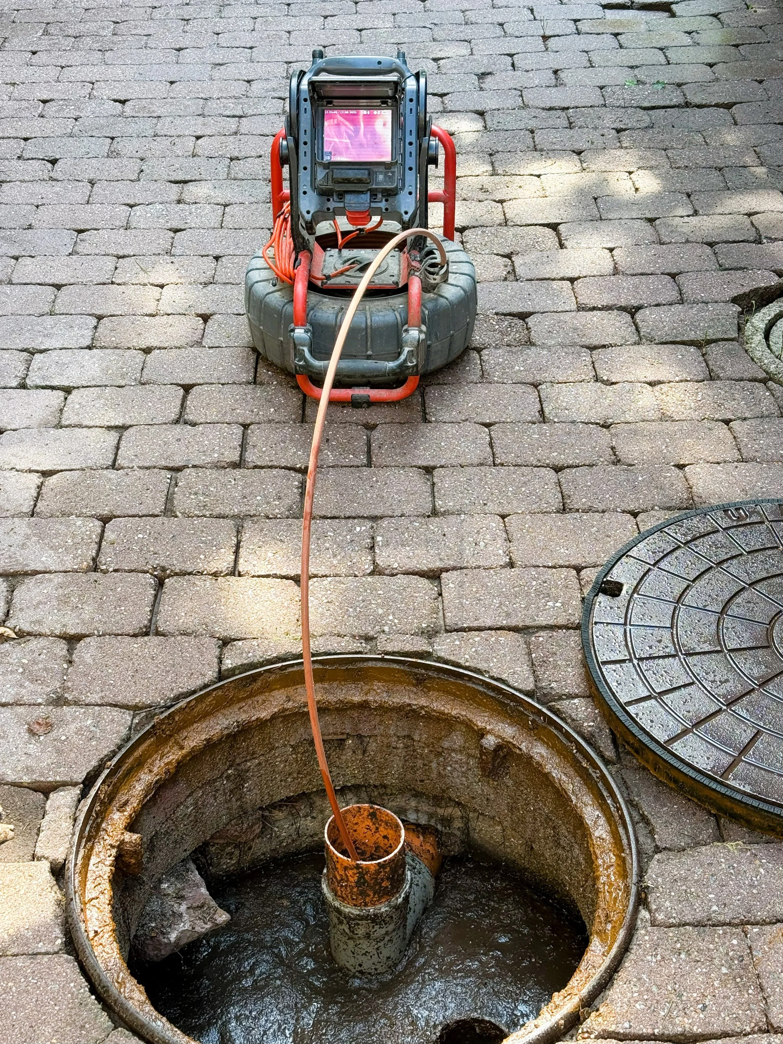 Sewer and drain specialist performing a camera inspection and drain clean from a grease trap.