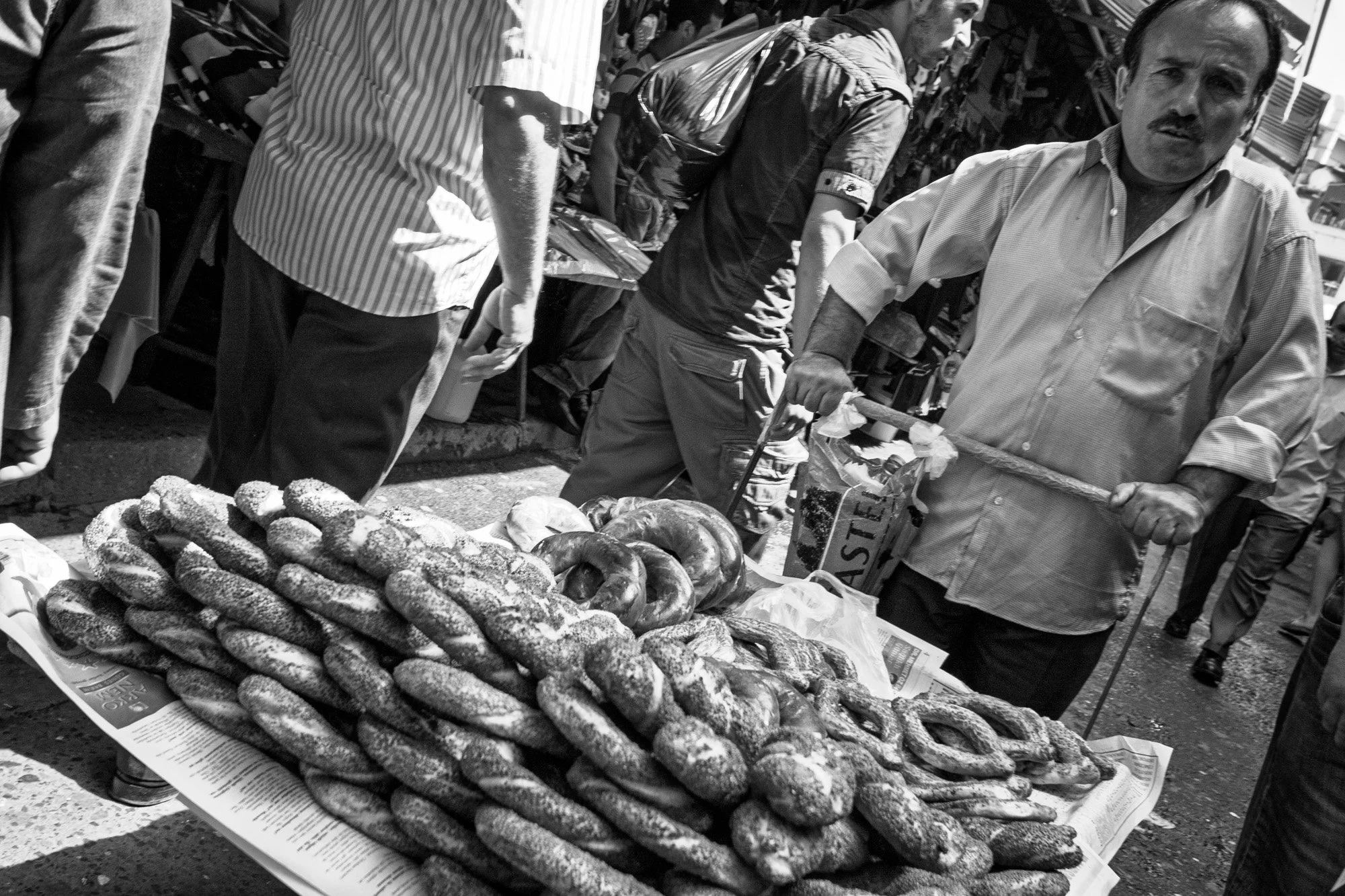 Street vendor selling simit sesame bread rings at a busy Istanbul market, black and white — bCLPhoto