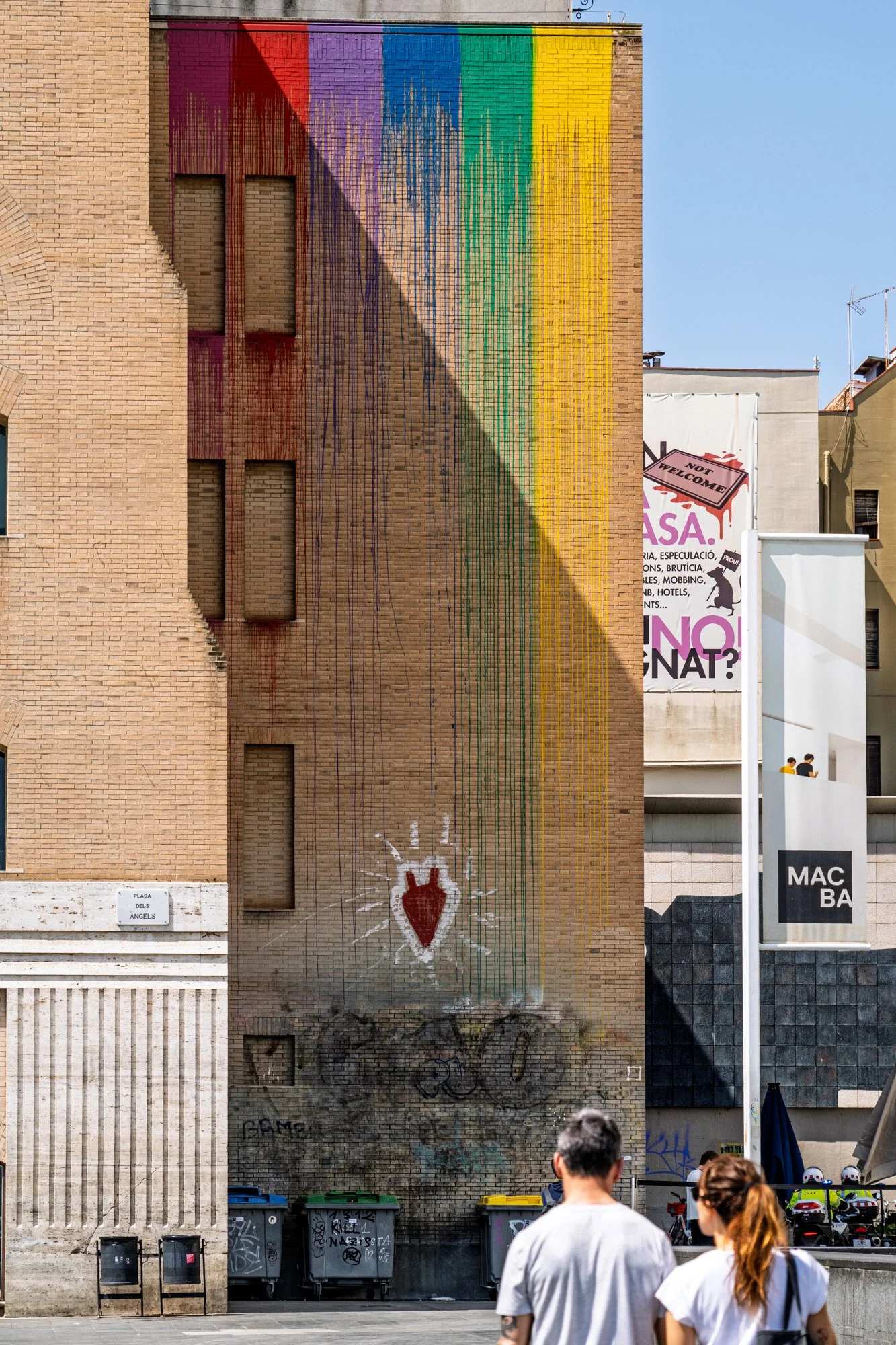 Couple watching rainbow paint dripping down a wall at Plaça dels Àngels, el Raval, near MACBA, Barcelona — bCLPhoto