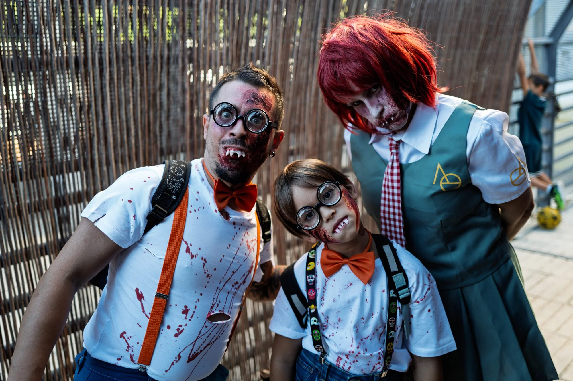 Family in vampire nerd costumes with round glasses, fangs and orange bow ties, Sitges — Leica Q3